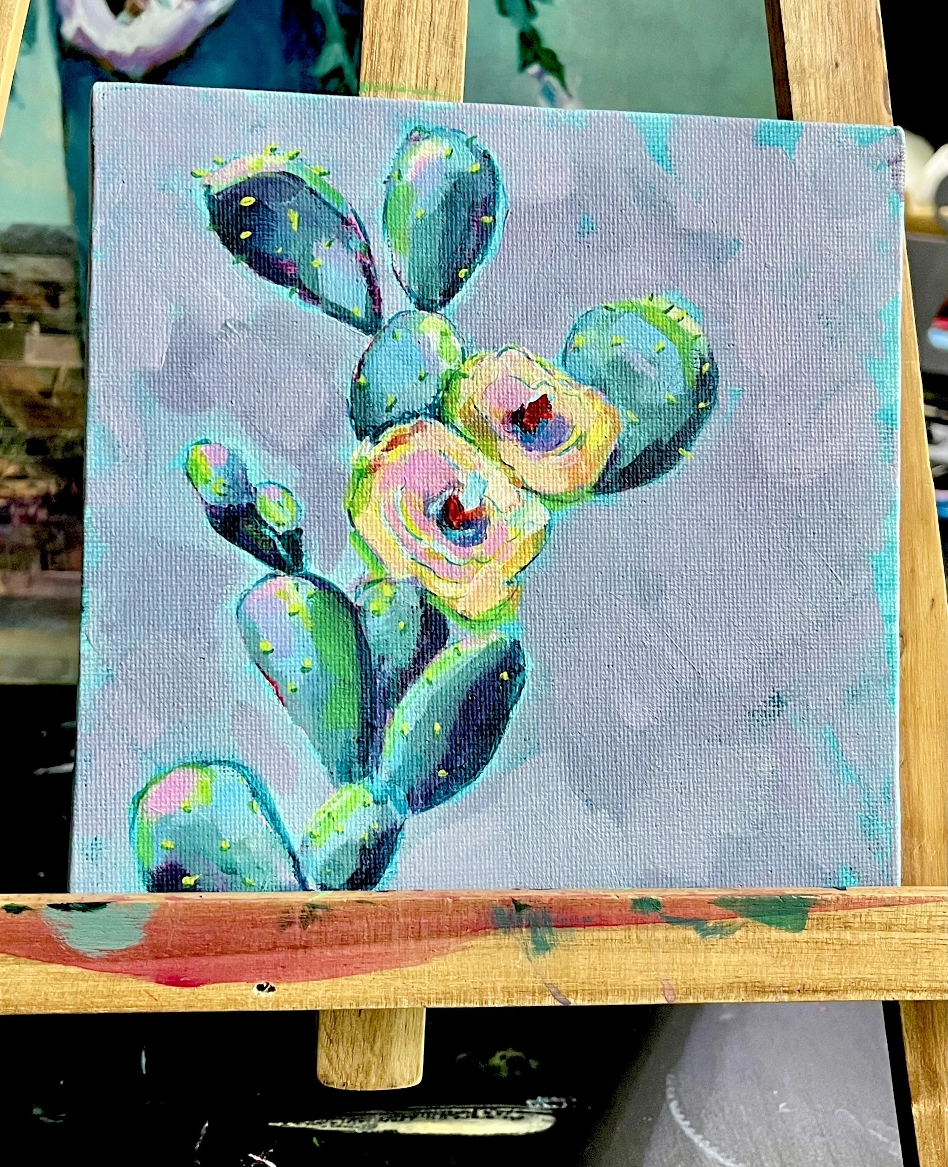 Vibrate painting of a flowering cactus still on the easel.