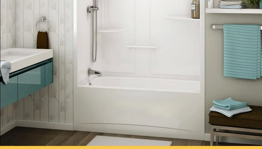 Bathroom with a bathtub, a vanity with a sink, blue and white towels, a brown cushioned stool, and shelves with toiletries.