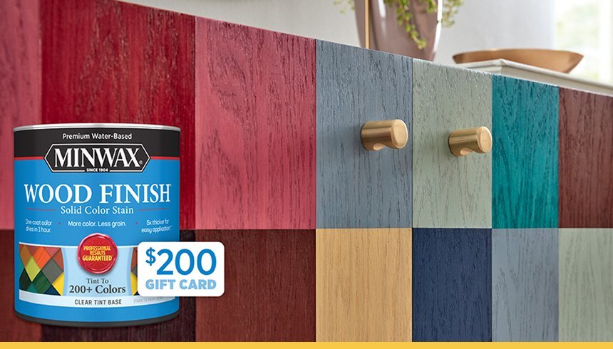 Colorful painted wooden cabinet with gold knobs, a Minwax wood finish stain can, and a $200 gift card sticker.