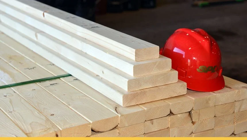 Stack of wooden planks with a red construction helmet placed on top.