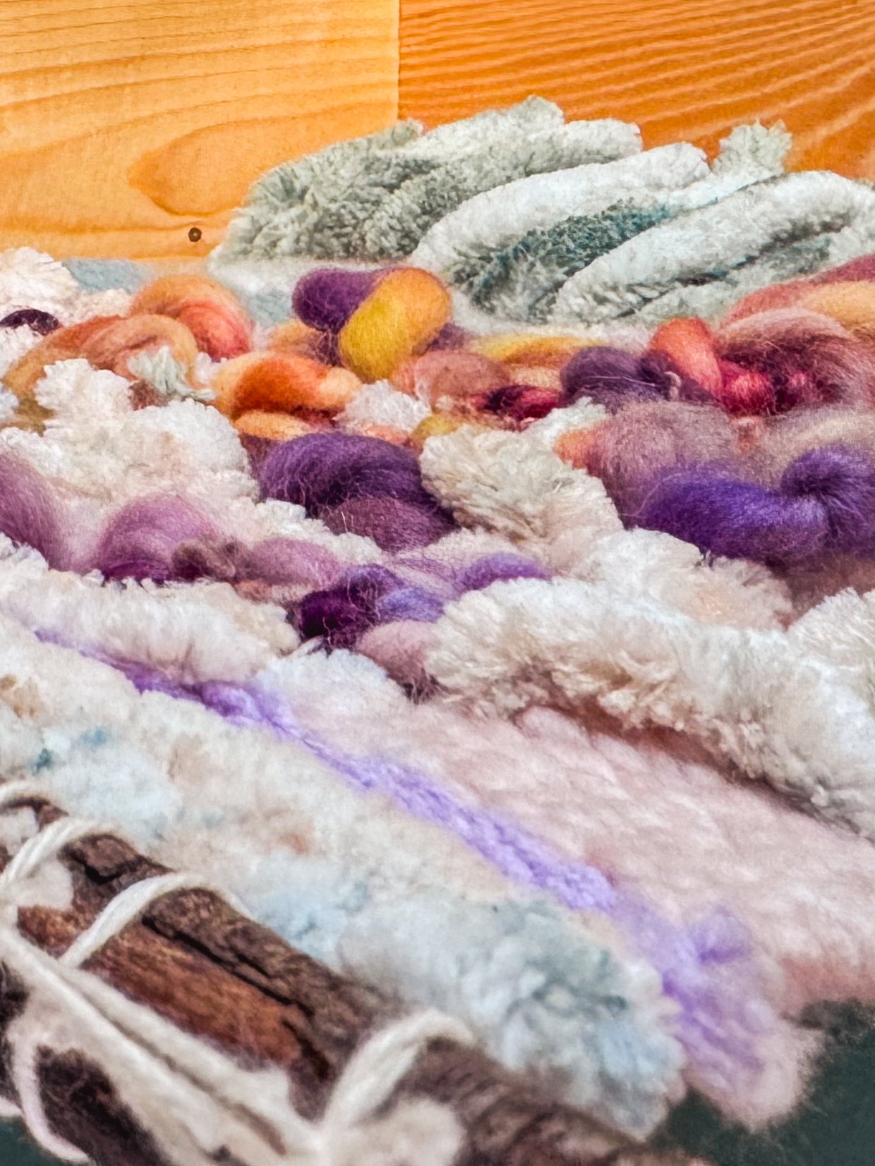Close-up view of colorful spun wool yarns on a woven basket with wooden background