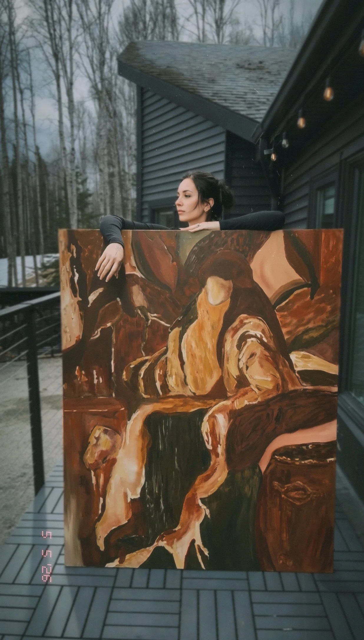An artist woman with a large abstract contemporary abstract artist painting in front of her