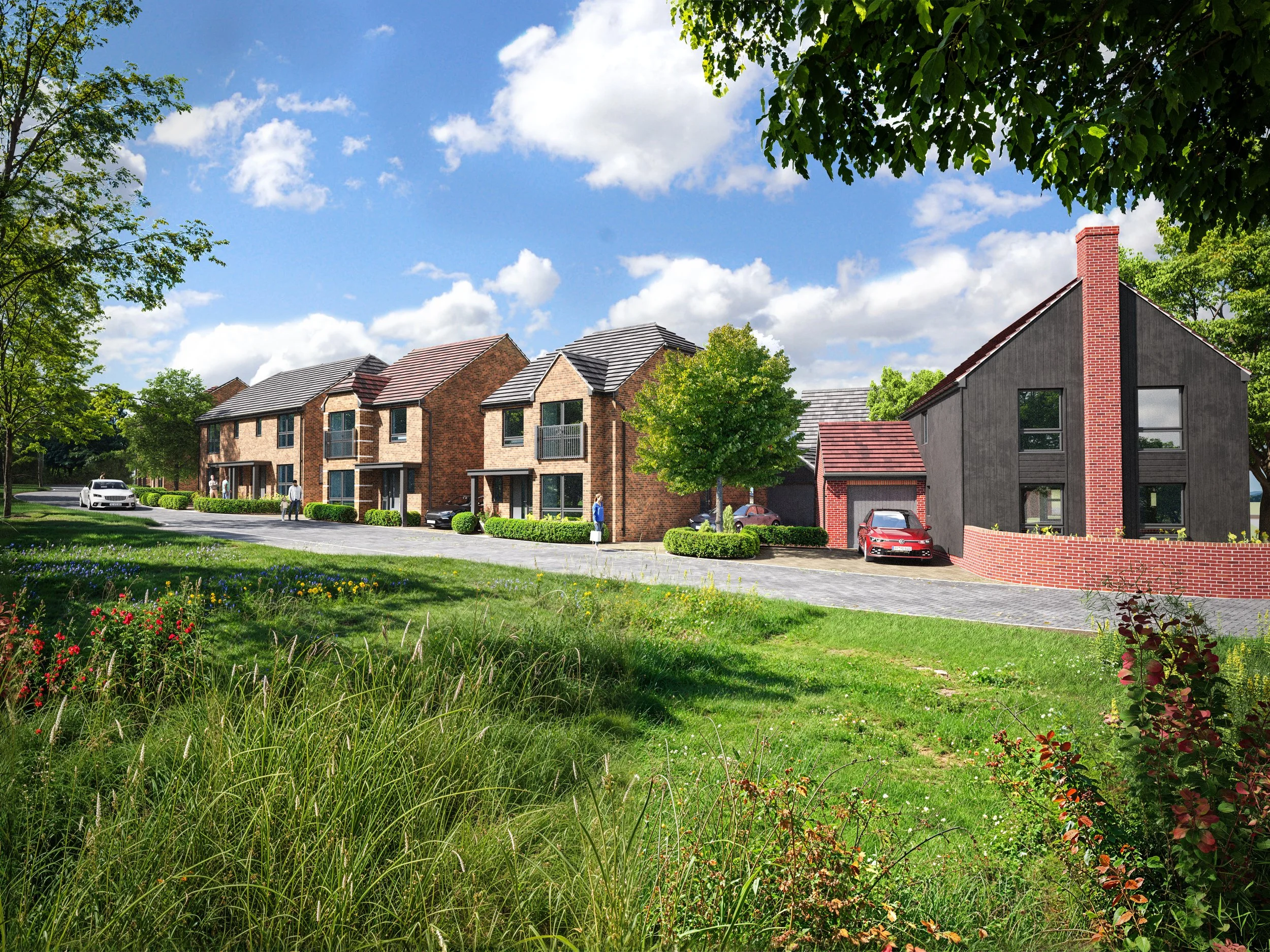 A neighborhood with modern townhouses featuring brick and dark wood facades, surrounded by lush green trees, a well-maintained lawn, and a few parked cars under a bright blue sky with scattered clouds.