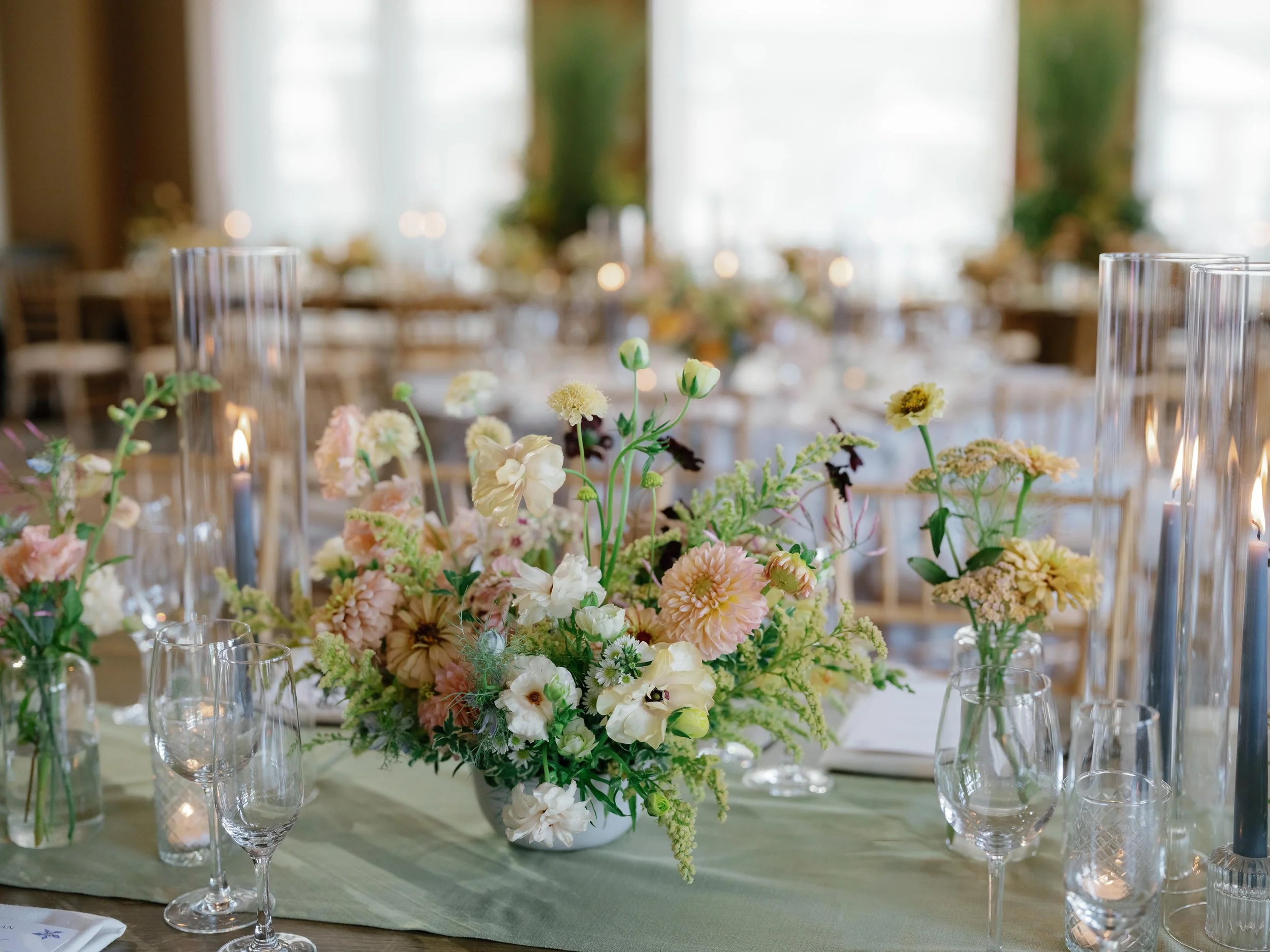 a pink and white floral bouquet on top of tables at a wedding dinner celebration