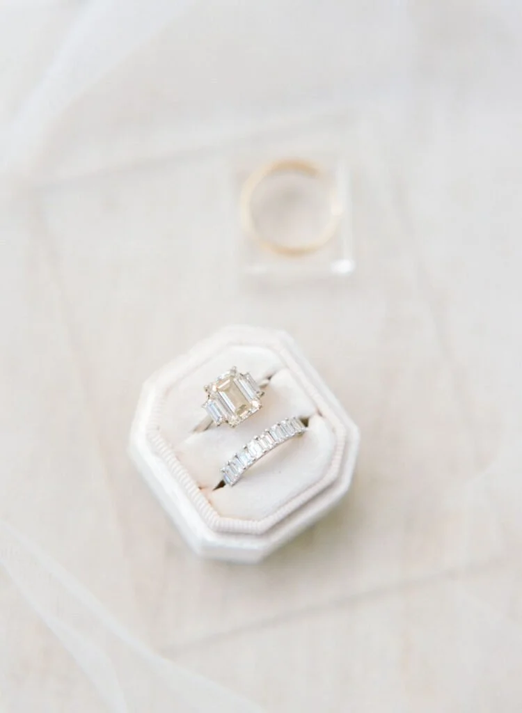 Emerald-cut engagement ring and diamond band for couples who just got engaged and love timeless style.