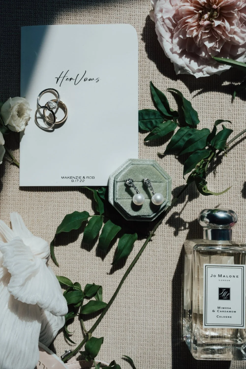 Wedding rings, vow book, and florals styled for a romantic New England wedding weekend itinerary.