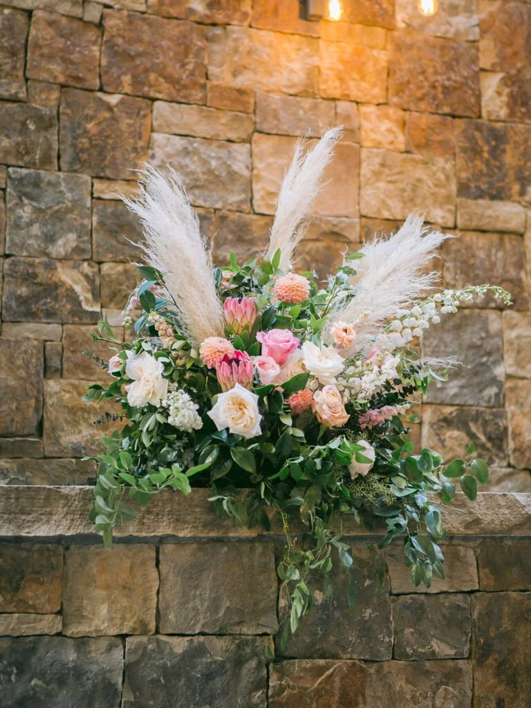 beautiful floral arrangement against a stone wall 