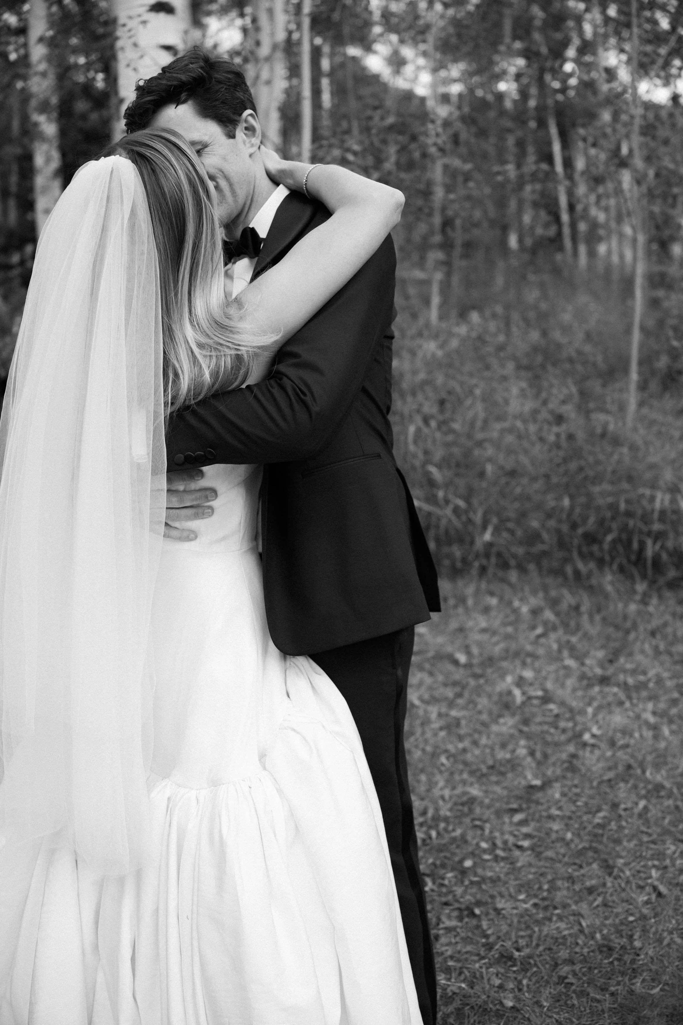 a bride and groom kissing each other right after their wedding ceremony in colorado mountains