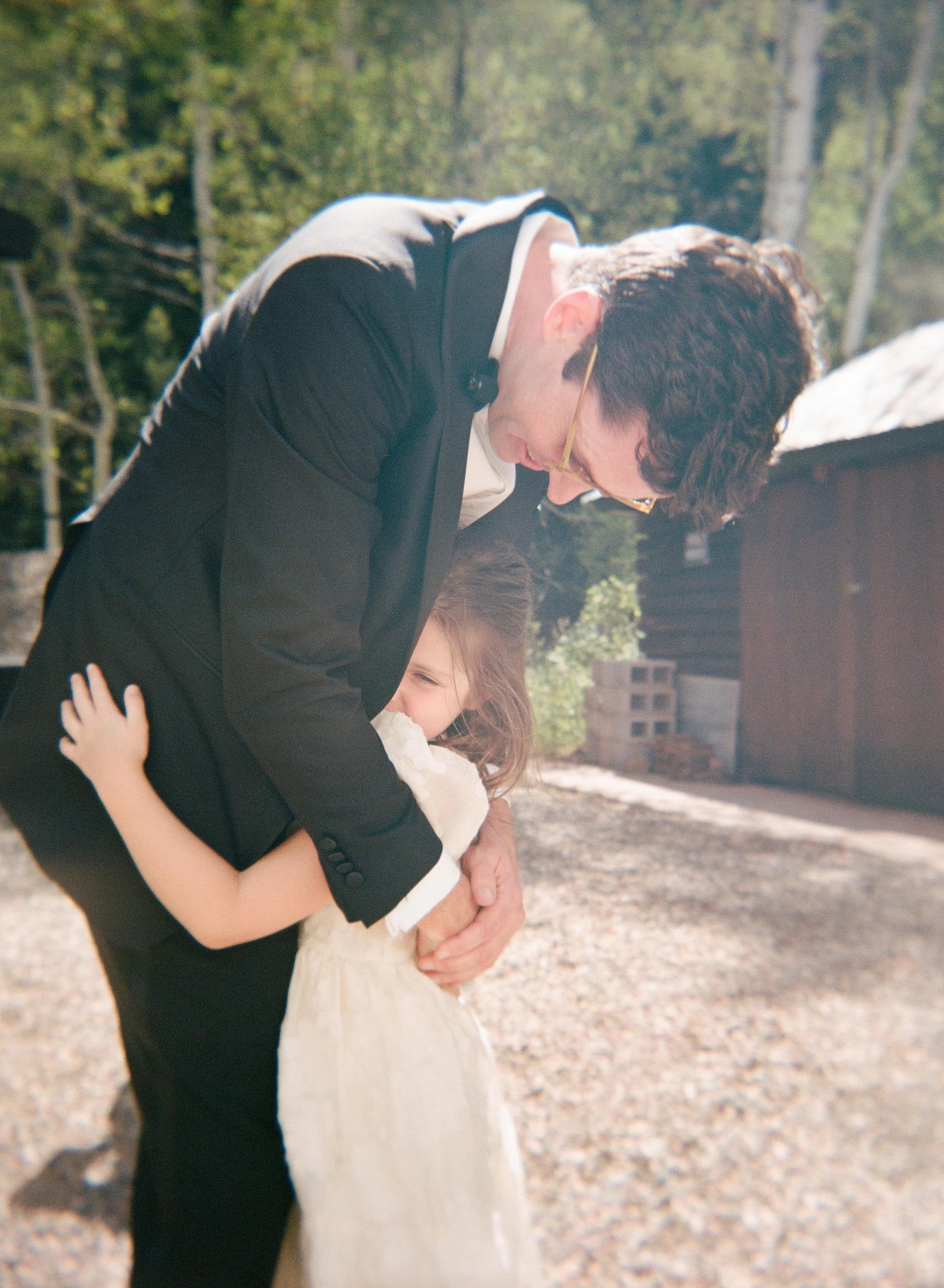 a groom hugging his niece on the day of his wedding