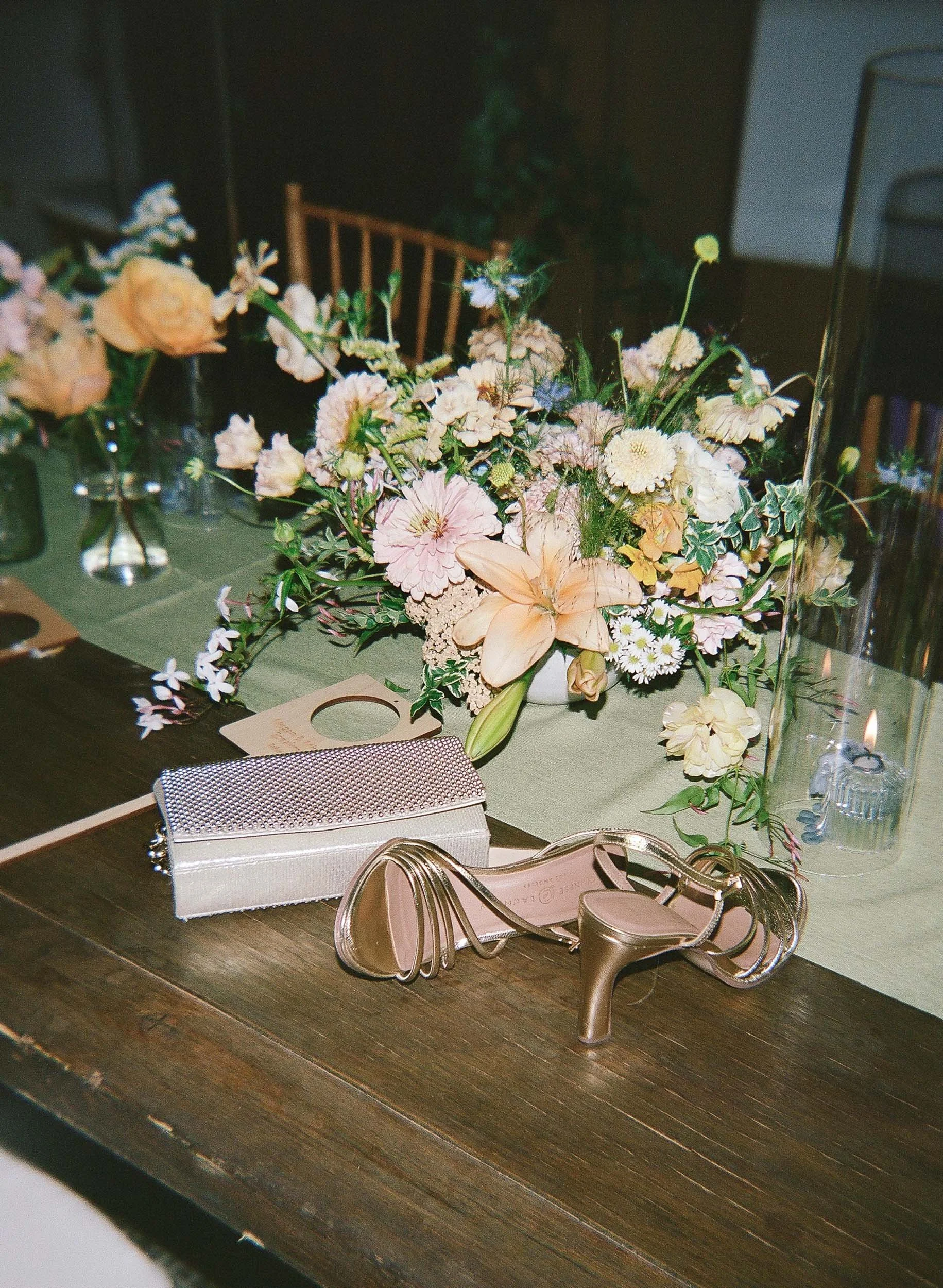 a cute pink shiny clutch bag on top of a well decorated wedding table in colorado