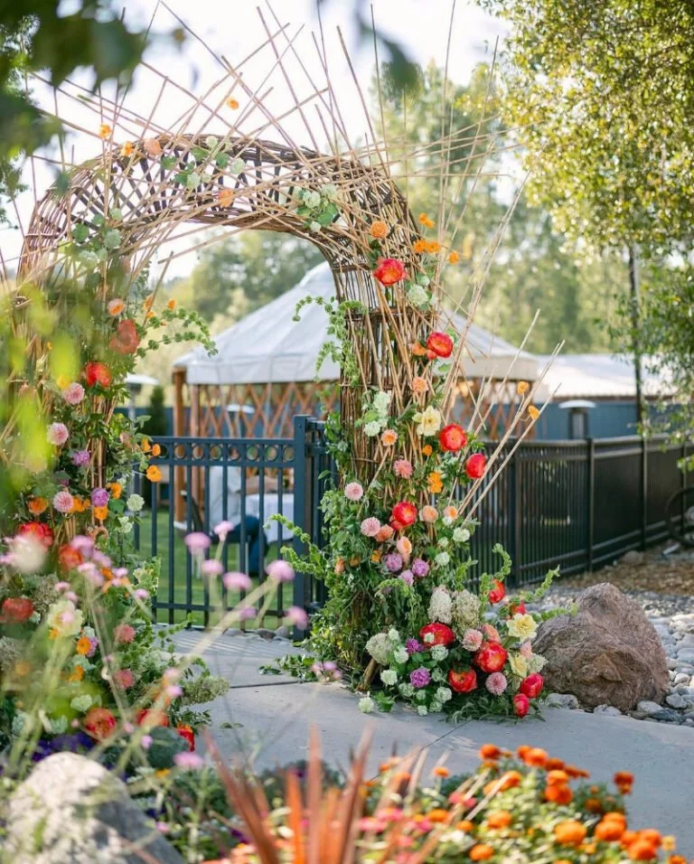 Spring wedding color palettes with vibrant florals and lush greenery framing a garden ceremony entrance
