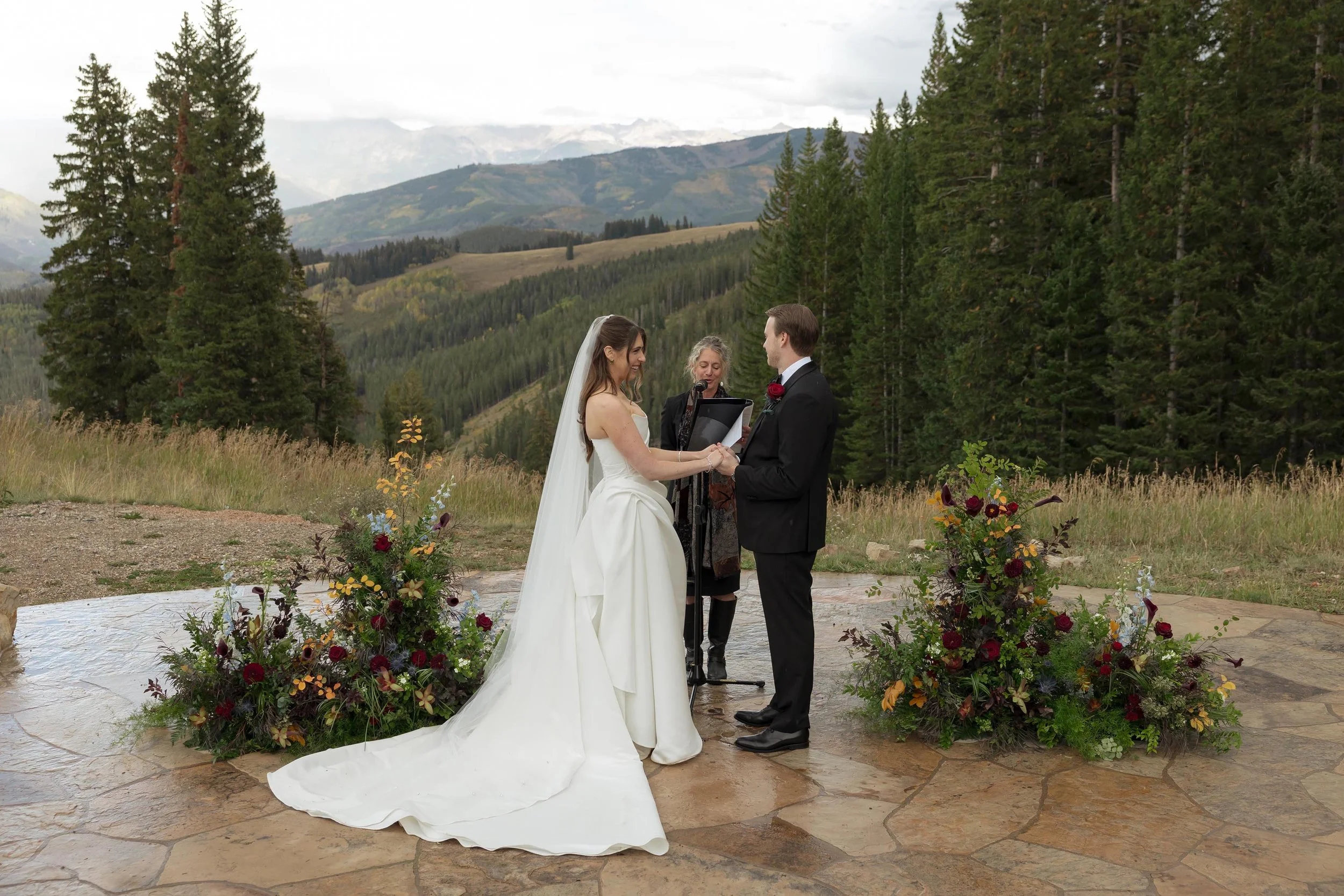a bride and groom getting married in front of mountains in beaver creek colorado