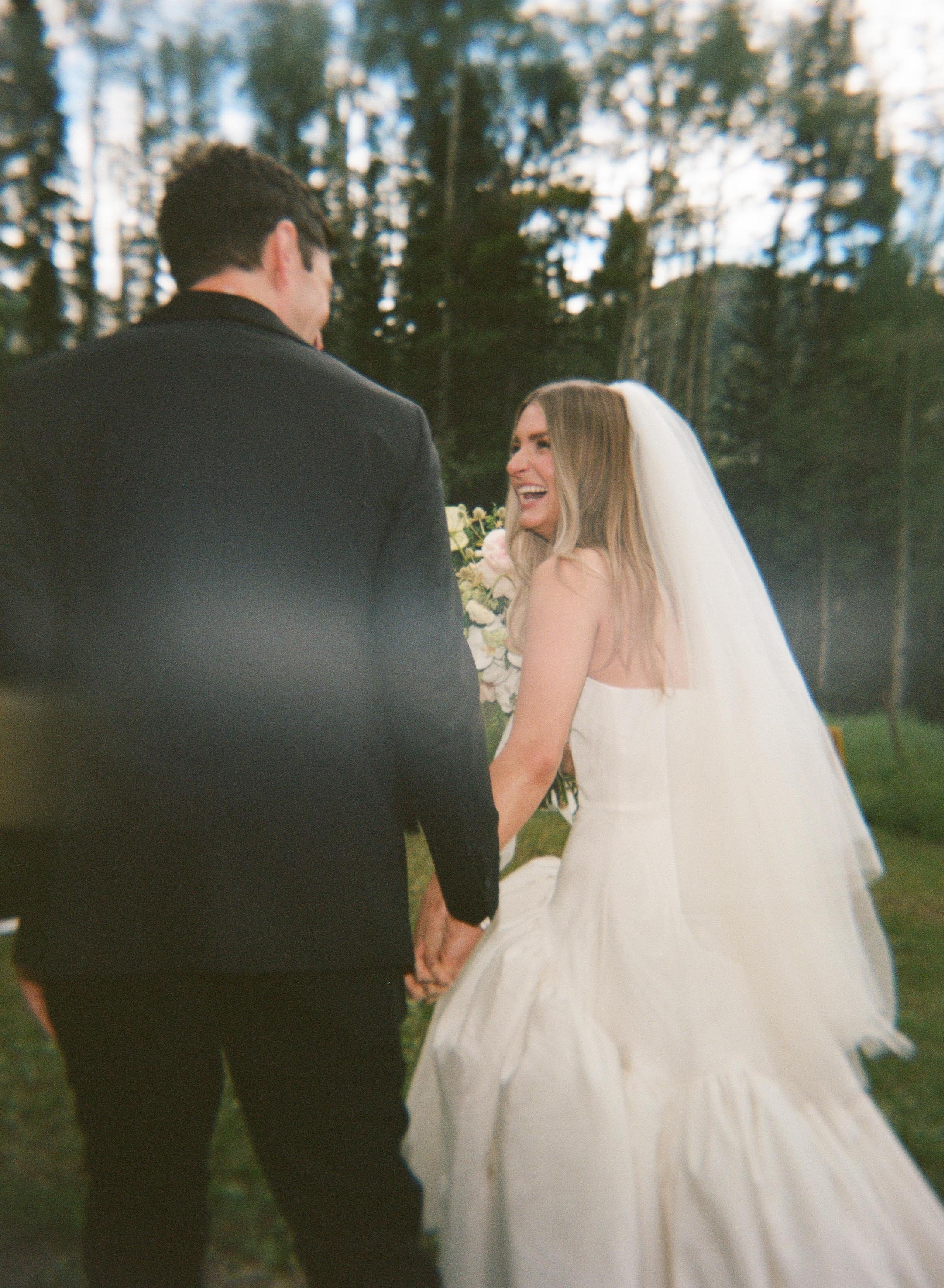 a newlywed couple smiling at each other after getting married in an outdoor colorado wedding