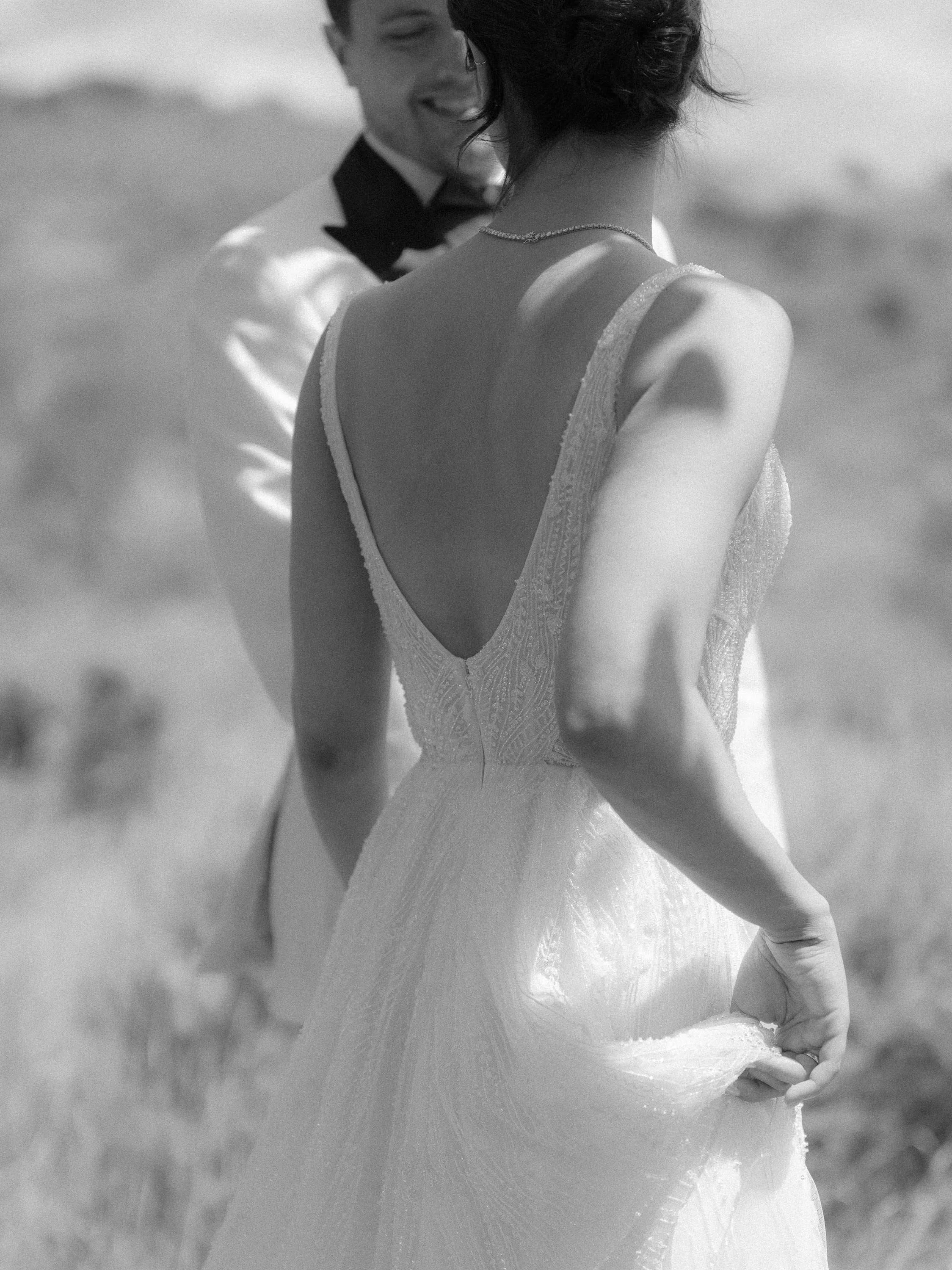 the back of a bride and groom holding hands