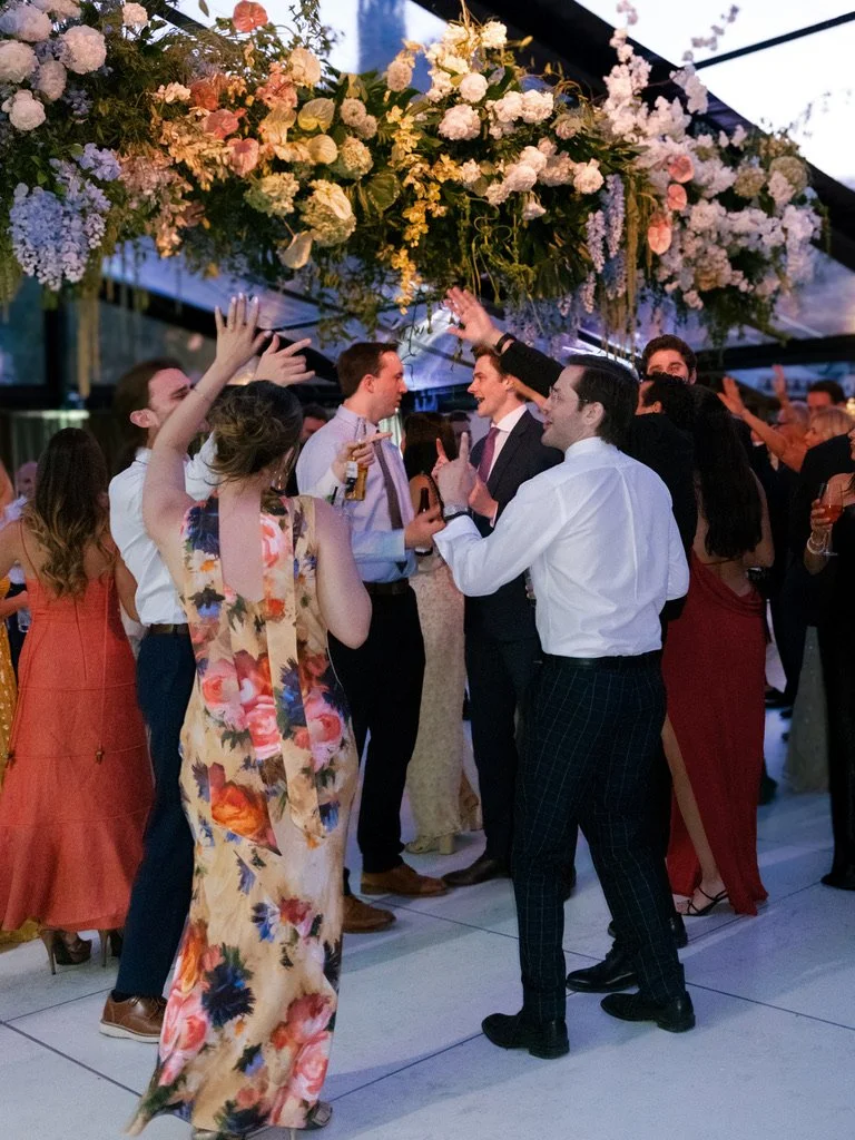 Guests dancing beneath floral installations at a luxury tented wedding reception in Beaver Creek, Colorado.