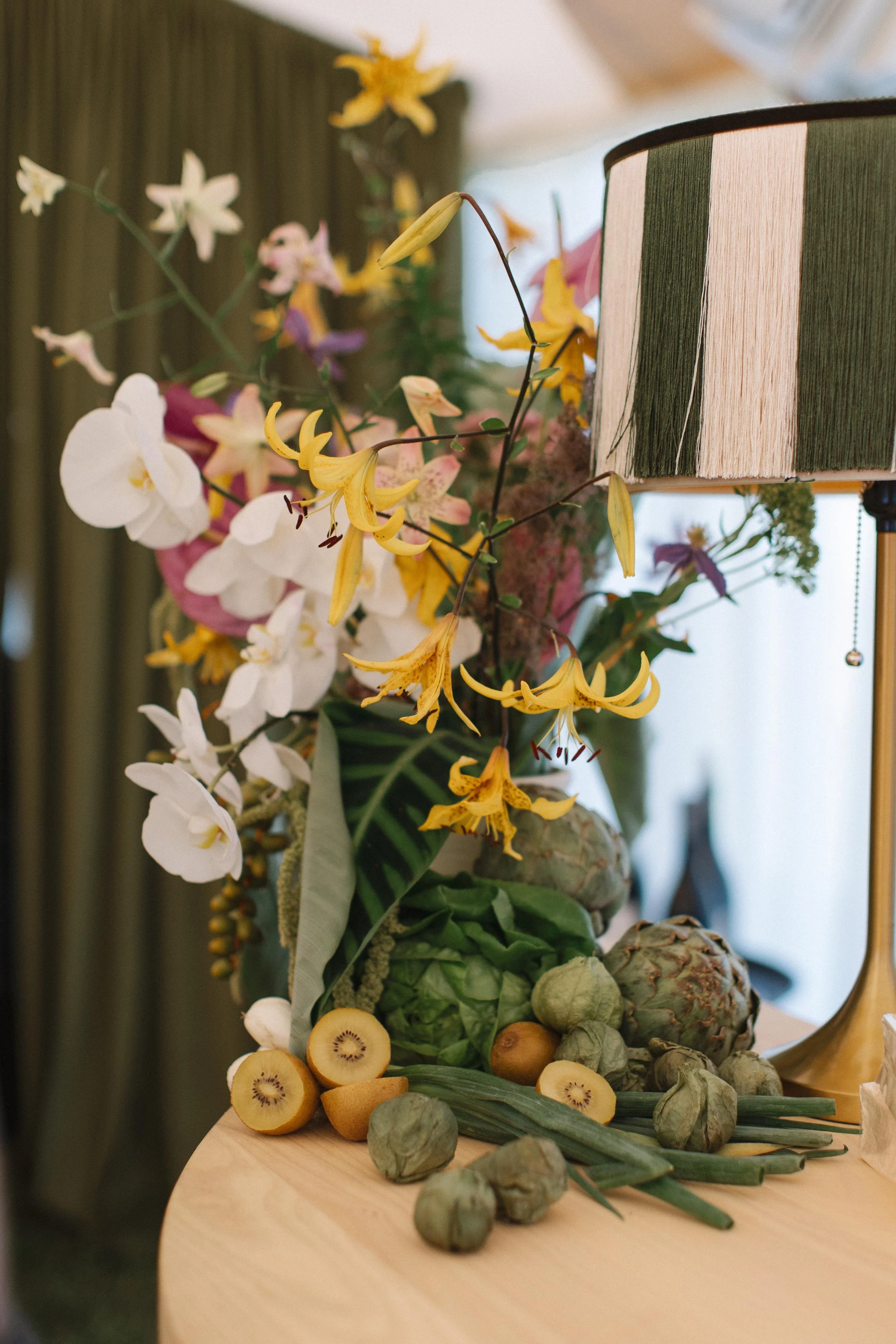 a bespoke yellow and white floral arrangement on an indoor wedding venue's tables