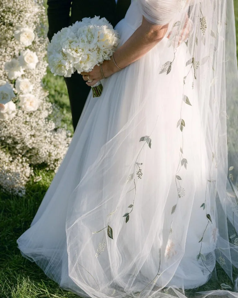 Boston wedding planner detail of bride’s embroidered veil and bouquet during outdoor garden ceremony