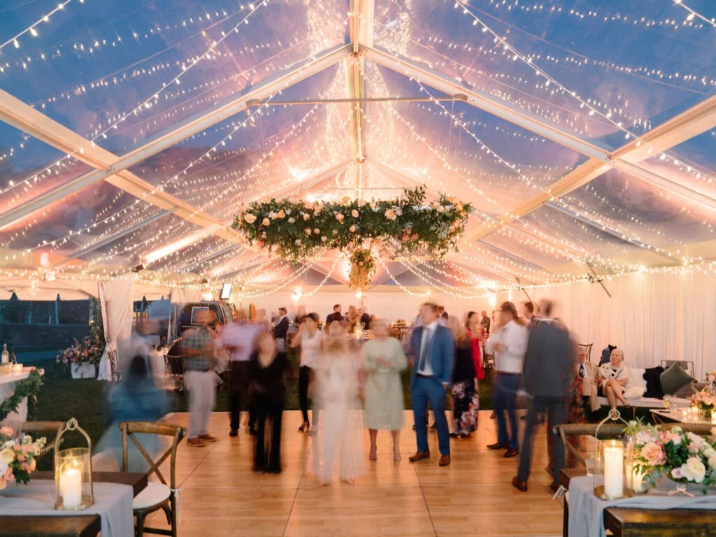 Magical wedding reception with string lights and dancing guests.
