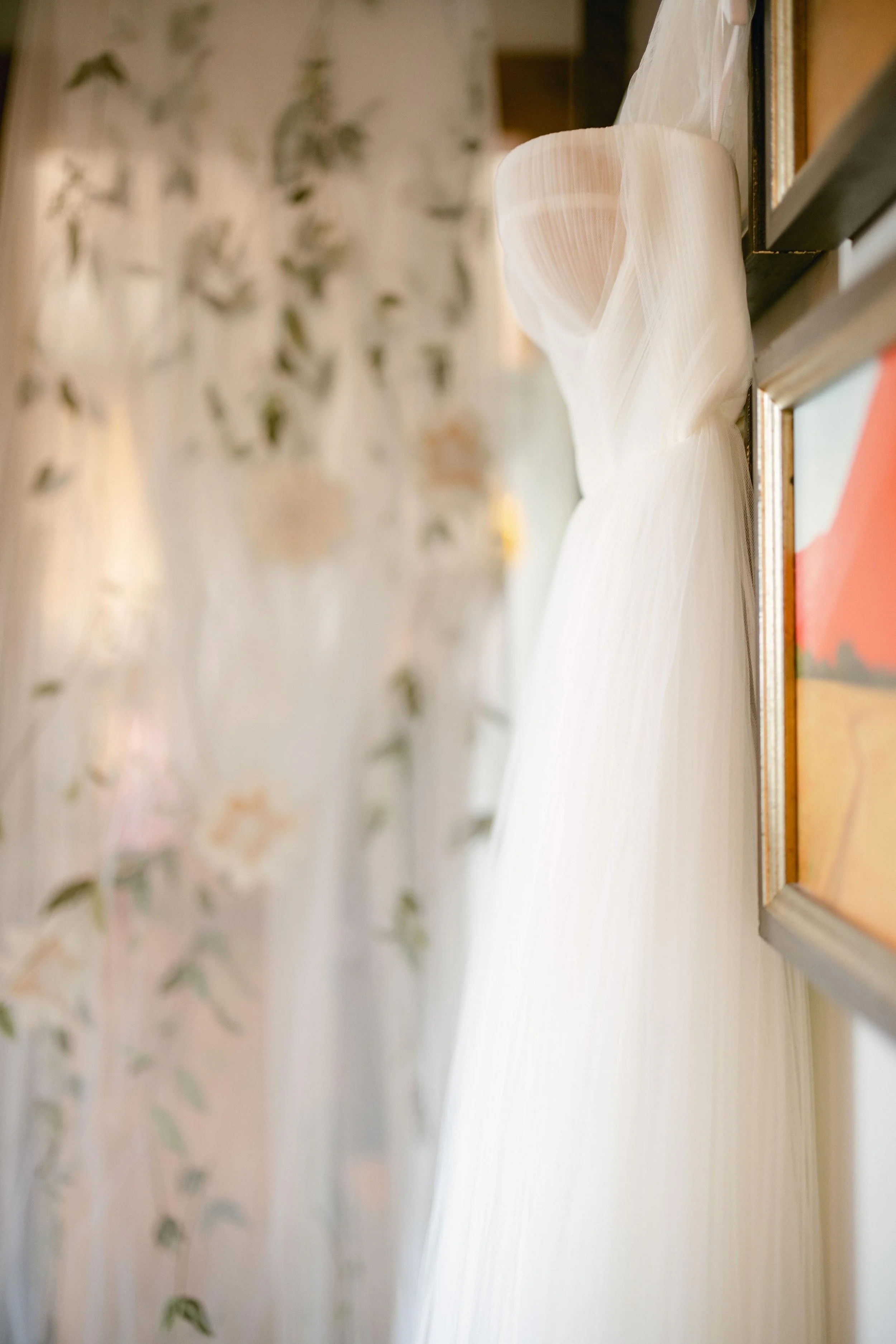 the bride's wedding dress hanging on a hanger before the wedding