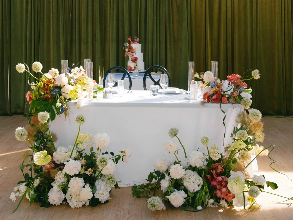 Elegant sweetheart table with lush floral installation at a Beaver Creek, Colorado tented wedding reception.