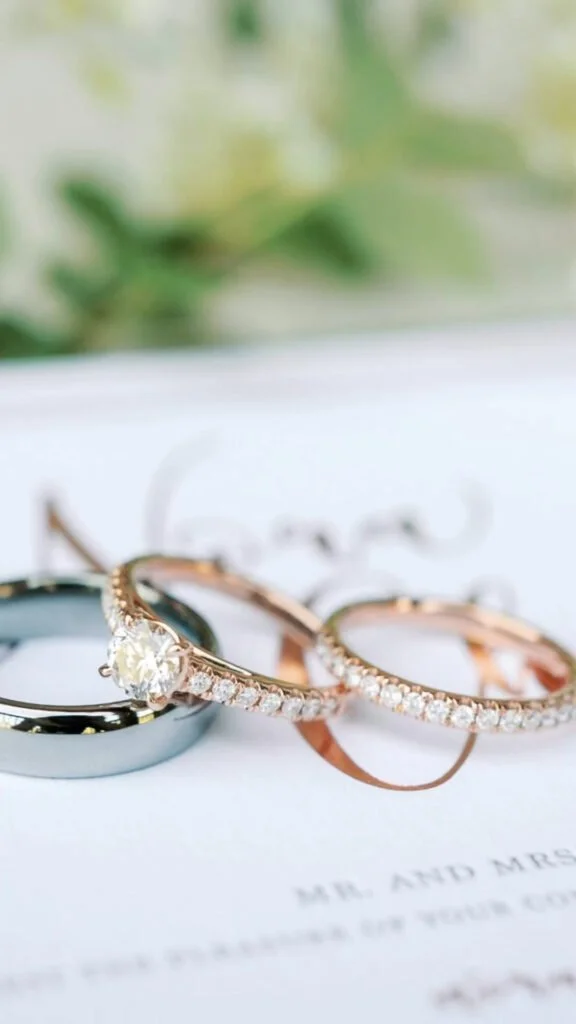 Elegant wedding rings styled with florals and calligraphy, perfect for romantic getaways in New England.