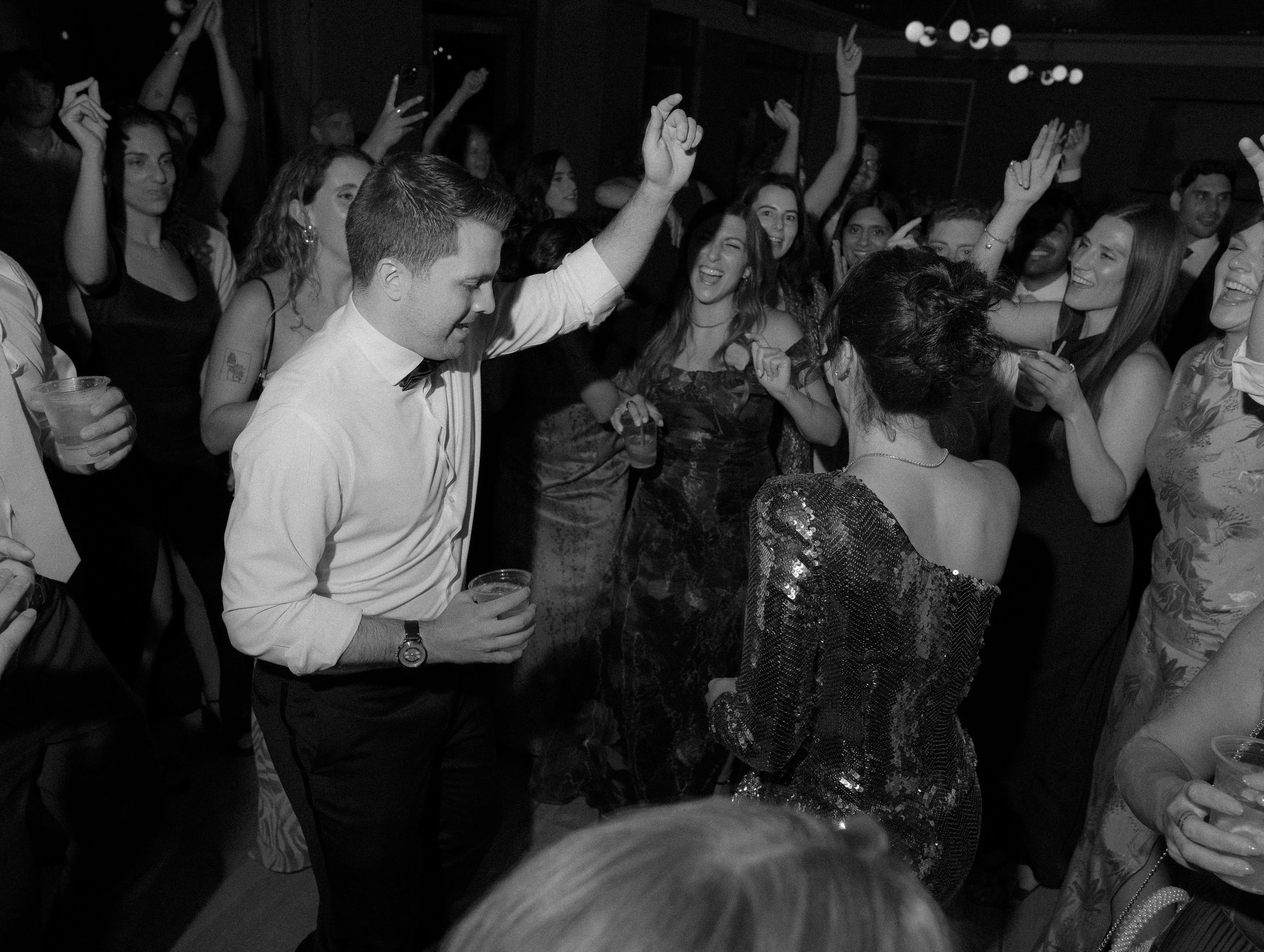 a newlywed couple dancing together with friends and family