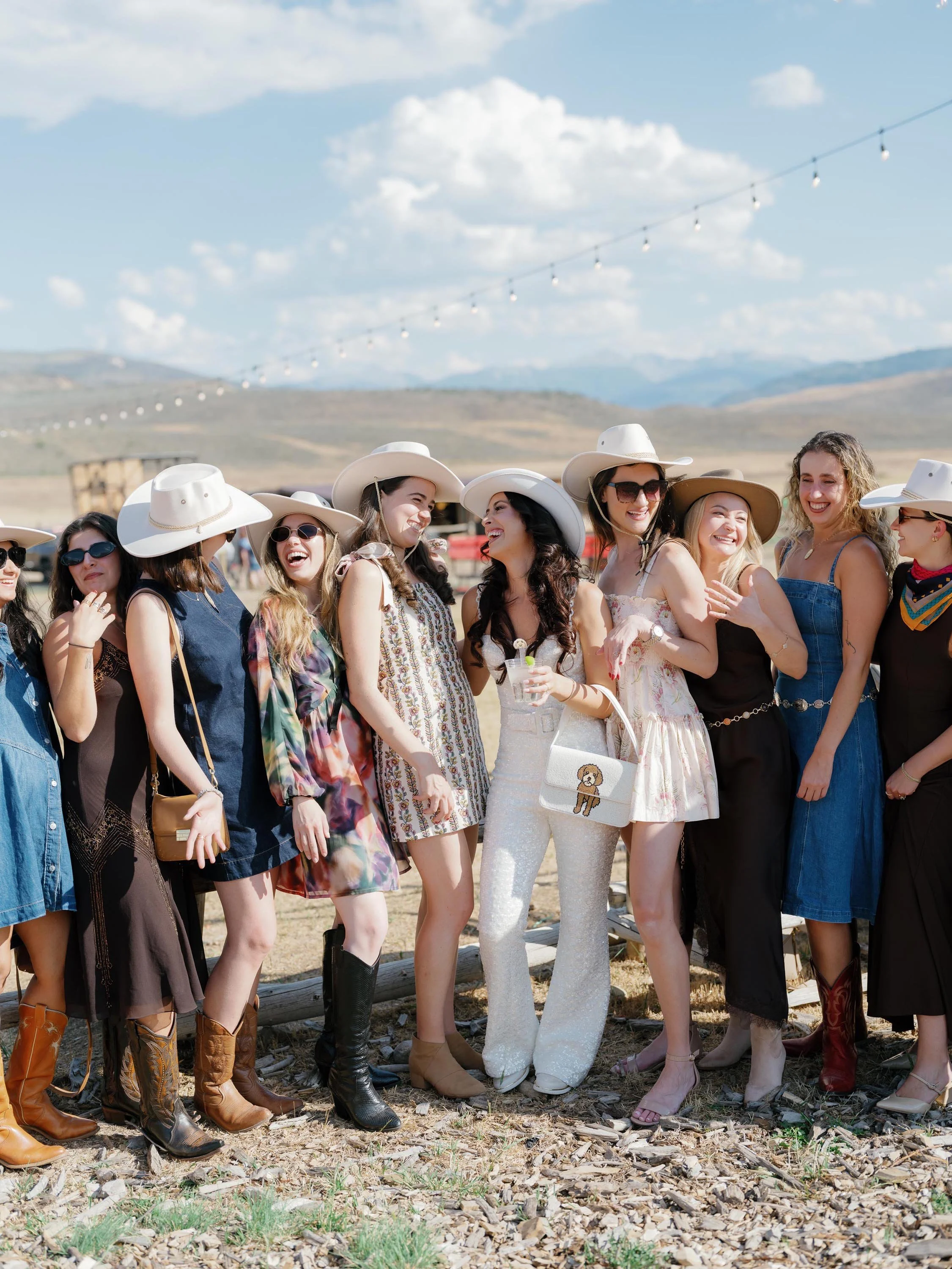 a bride and her bridal party laughing with each other on her wedding day