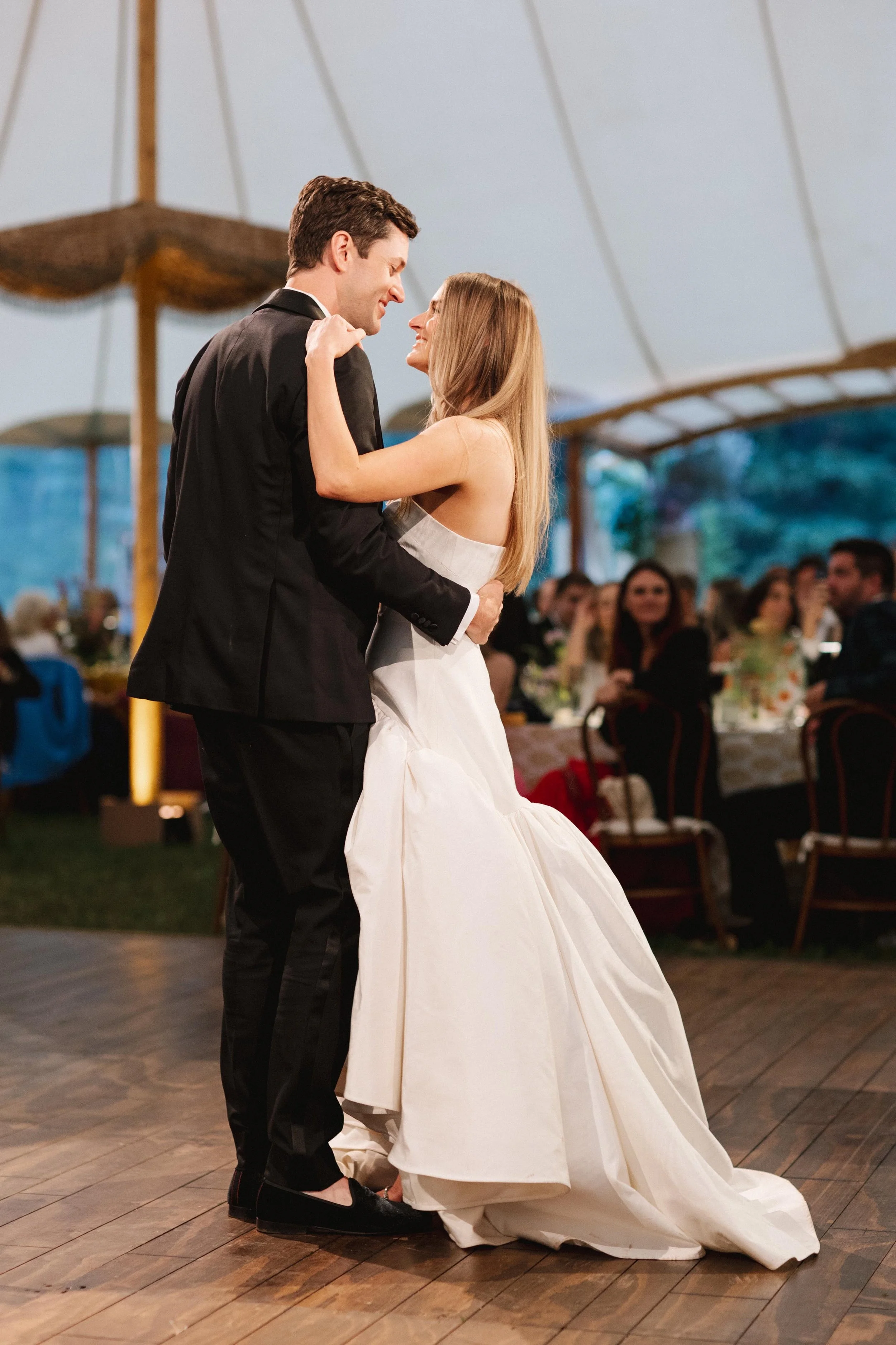 young bride and groom smiling at each other during their first dance as a married couple in colorado