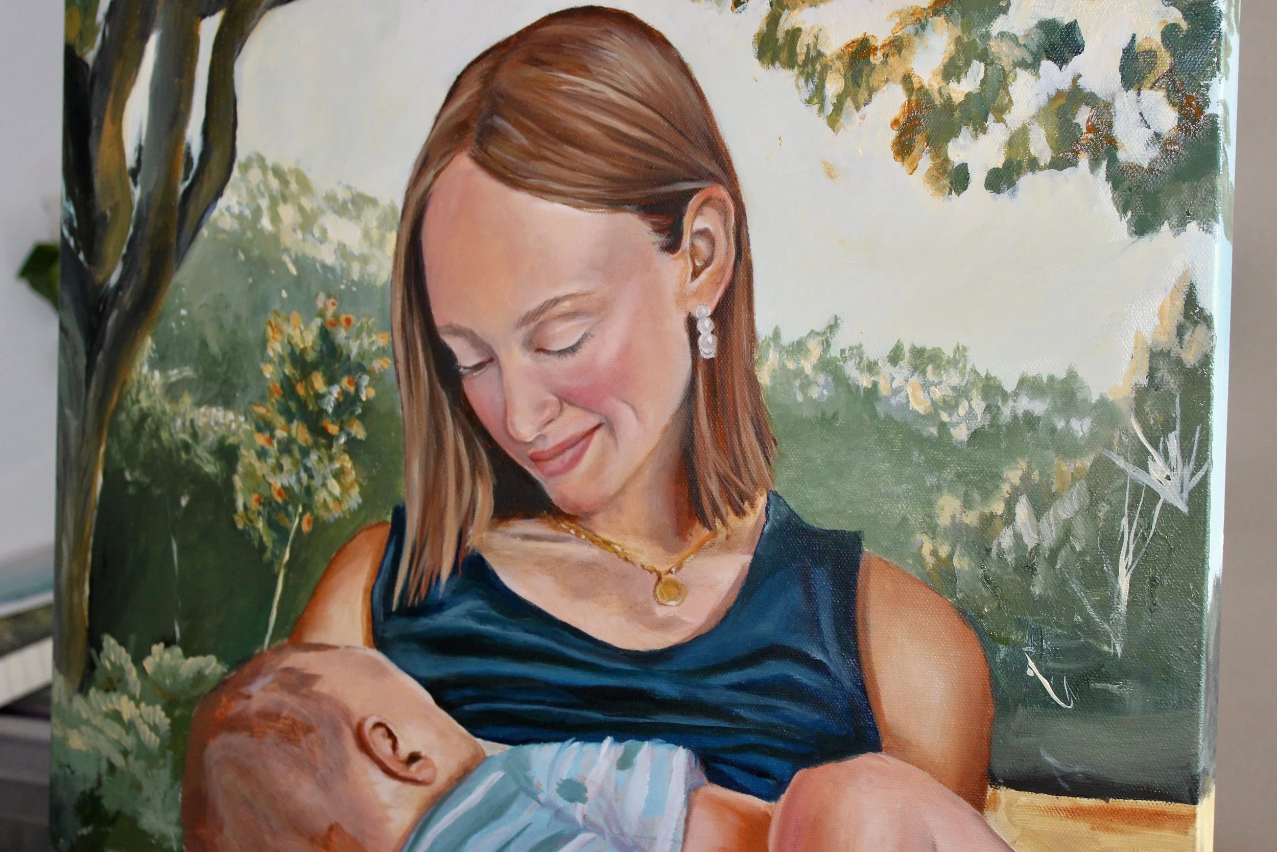 A painting of a woman with auburn hair, wearing a navy dress and jewelry, holding a sleeping baby with light hair, outdoors with green trees and foliage in the background.