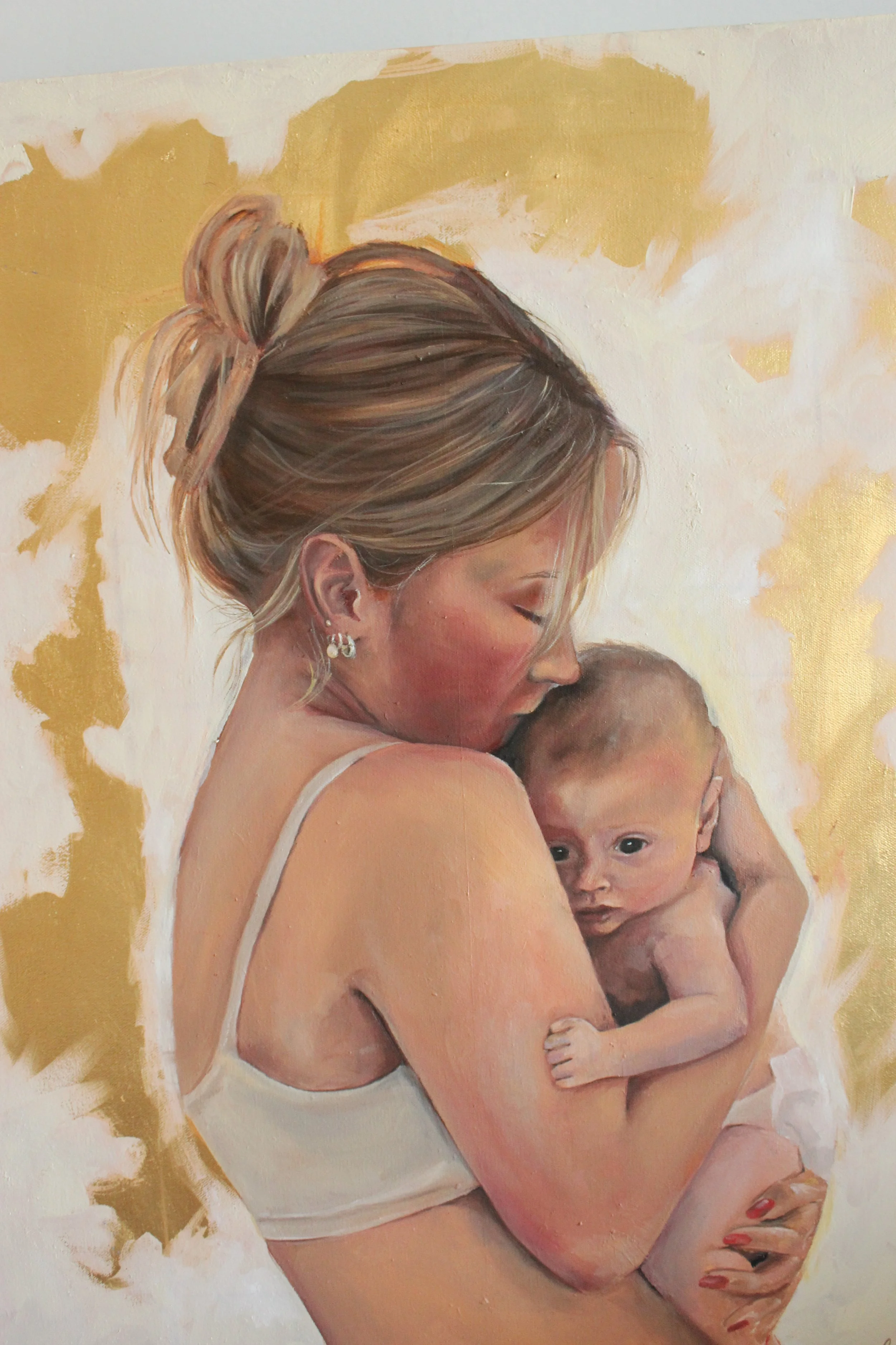Painting of a woman holding a baby, with a golden background and soft, warm colors.