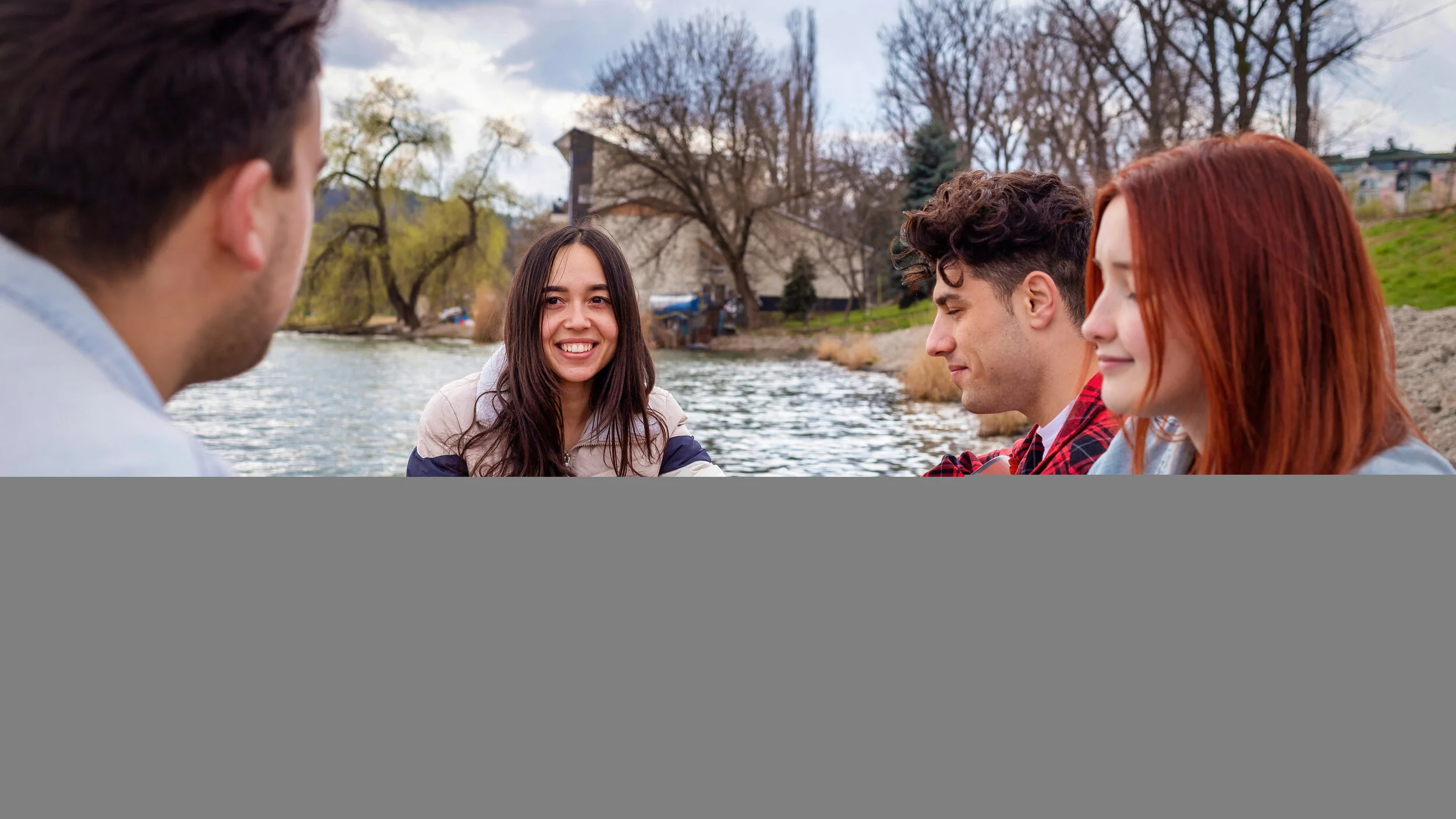 four-young-friends-singing-resting-playing-guitar-near-lake-park.jpg