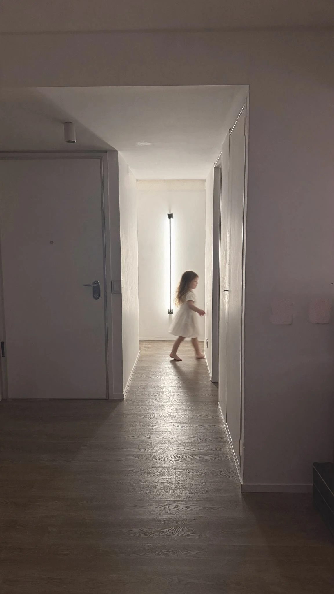 Pasillo con paredes blancas, piso de madera y luz vertical empotrada — proyecto de reforma en Buenos Aires