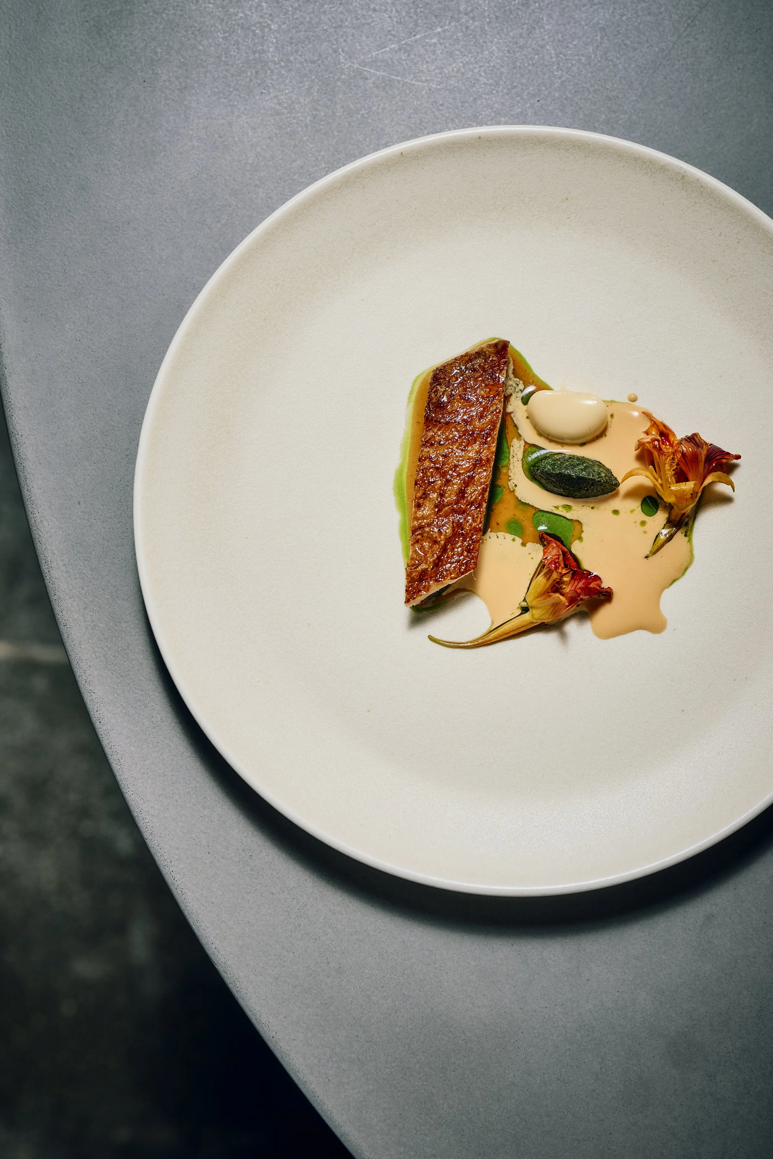 Duck from Kelly and Gary cooked above smoking applewood with finely chopped nasturtiums and a sauce of summer flowers.