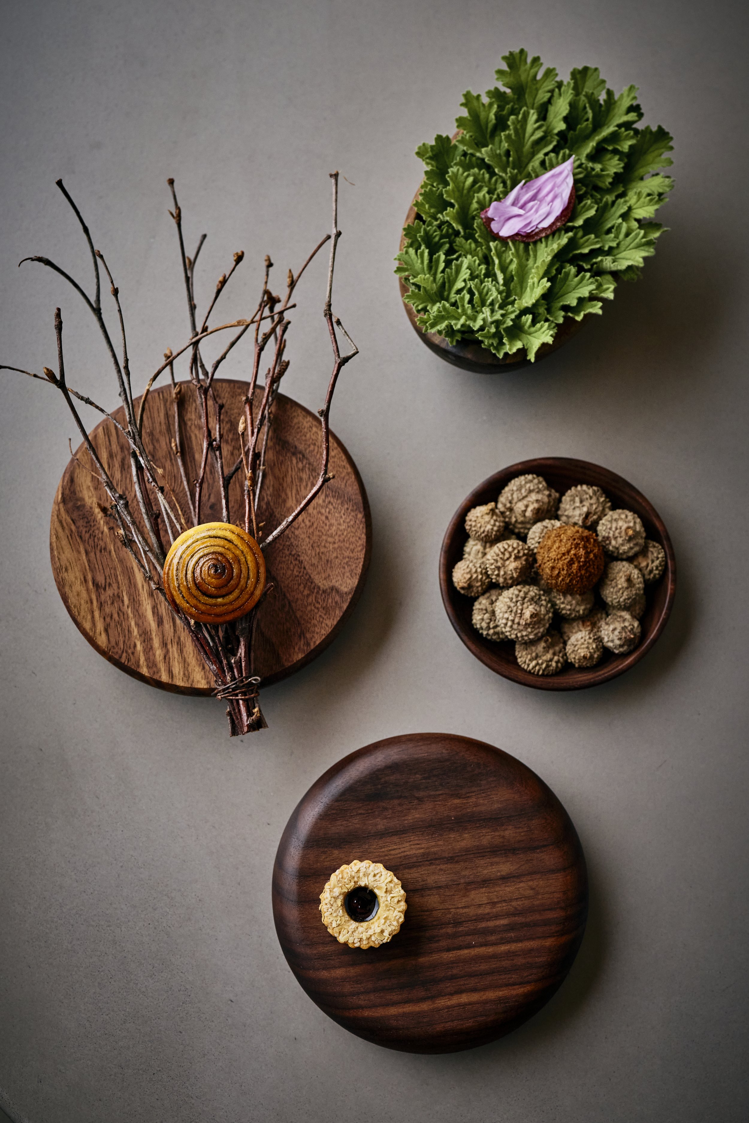 Clockwise from the left: Sweet wheat bun with birch syrup and brown butter, Rose geranium delight, Frozen acorn cake miso, toasted oats with oak aged quince vinegar and preserved damson. 