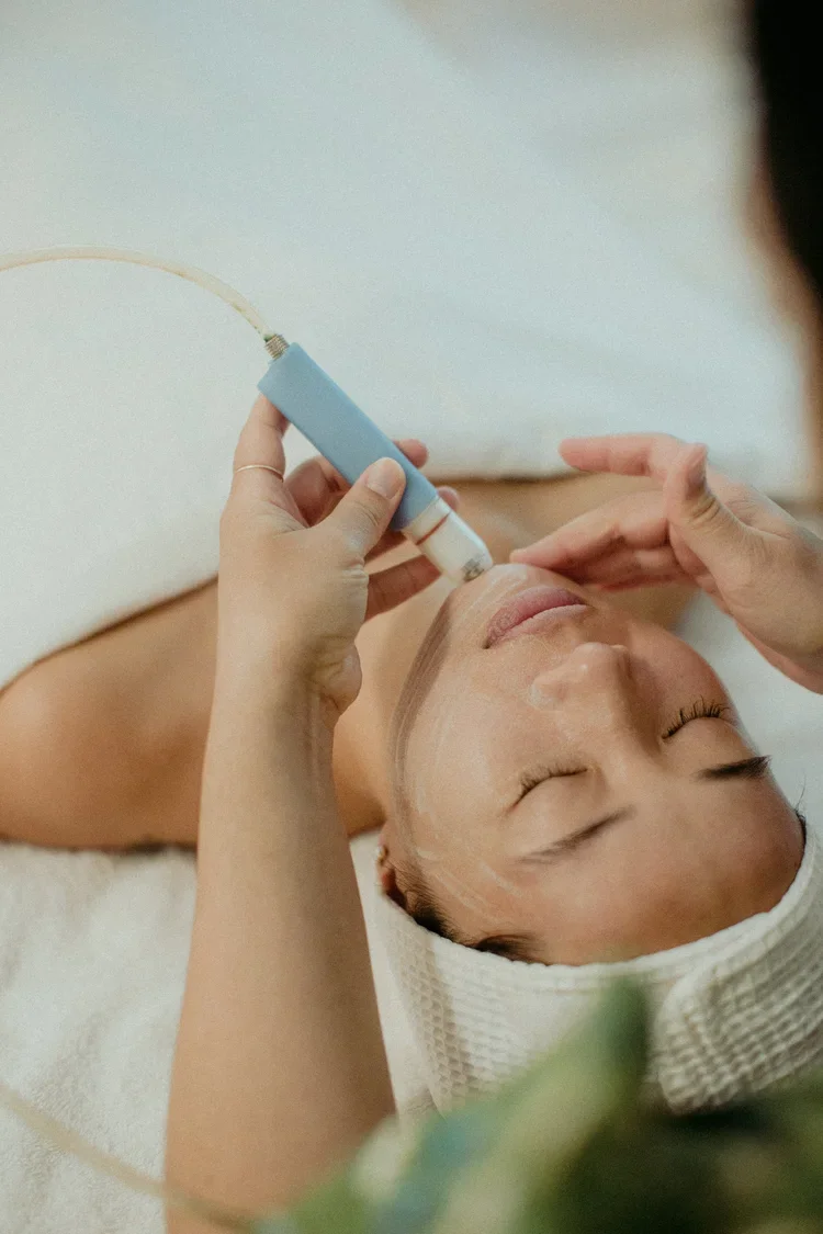 A woman receiving a facial treatment with a facial device in our studio.