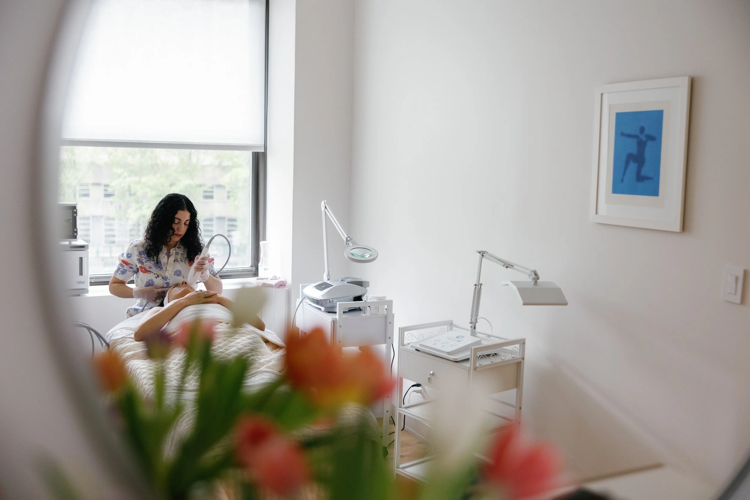 Elizabeth Fidler, Founder & Skincare Specialist, performing a facial treatment.