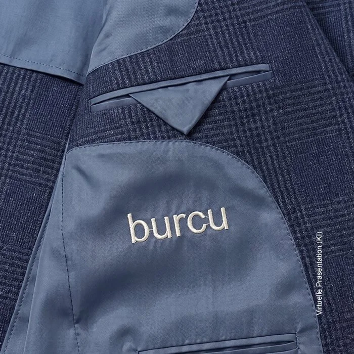 Detailaufnahme einer farbigen Monogramm-Stickerei mit Initialen im Seidenfutter eines Maßanzugs.