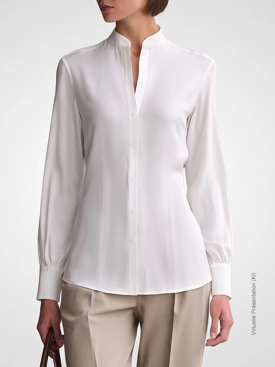 Weiße Damen-Bluse nach Maß aus hochwertigem Twill mit elegantem Nehru-Stehkragen und Manschettendetails, kombiniert mit beiger Hose im Atelier Burcu in Essen-Werden. 
