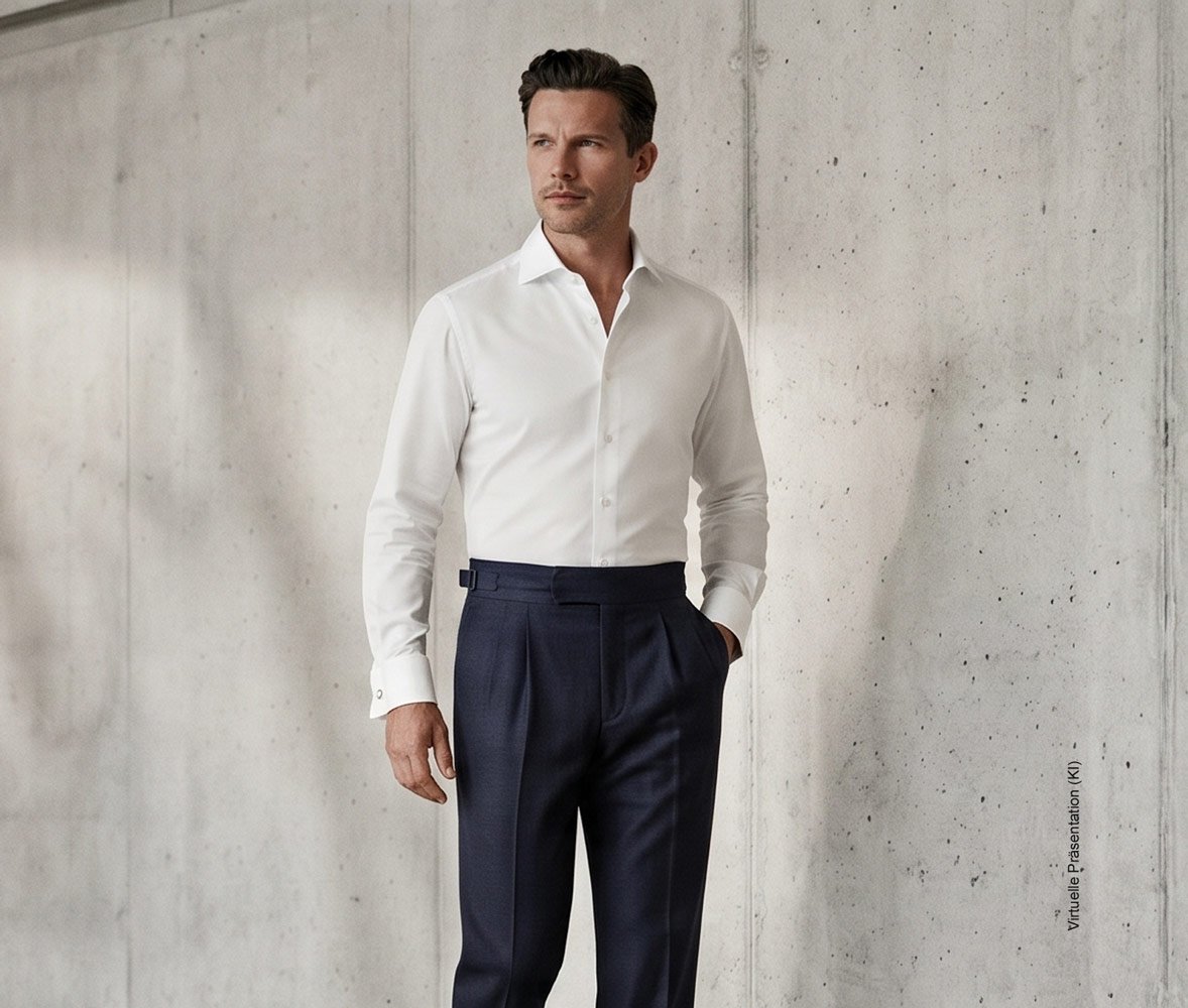 Stilvoller Gentleman in einem maßgeschneiderten weißen Business-Maßhemd mit Umschlagmanschette und dunkler Bundfaltenhose im Atelier Burcu in Essen-Werden.