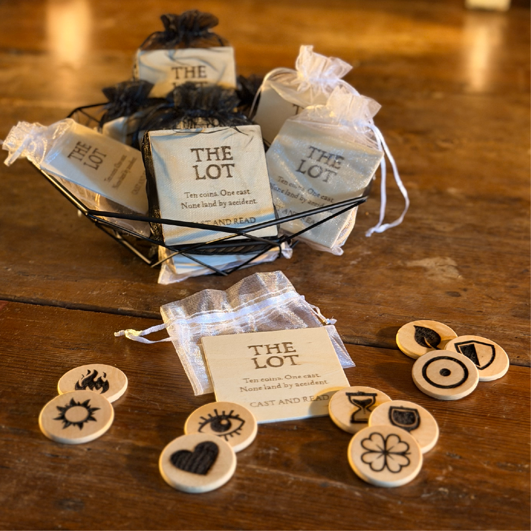 Set of wood-burned divination coins with symbols, packaged in muslin bags labeled ‘The Lot’”