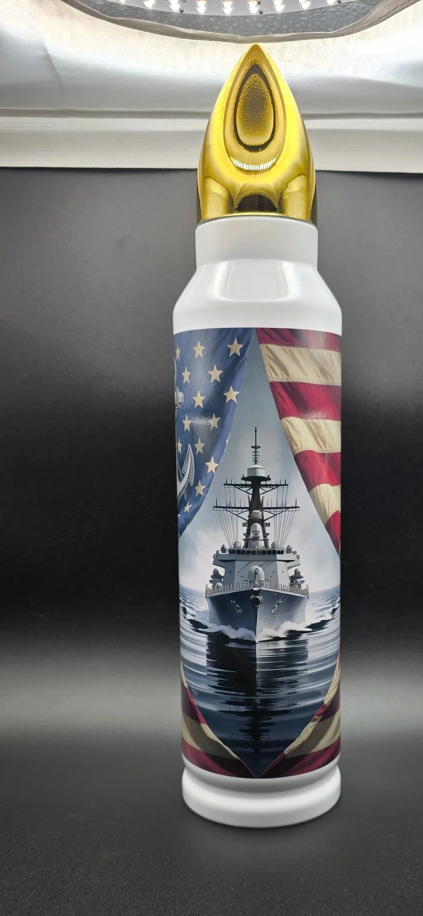 Close-up of a custom sublimated bullet-style tumbler featuring a U.S. Navy battleship and patriotic American flag artwork.
