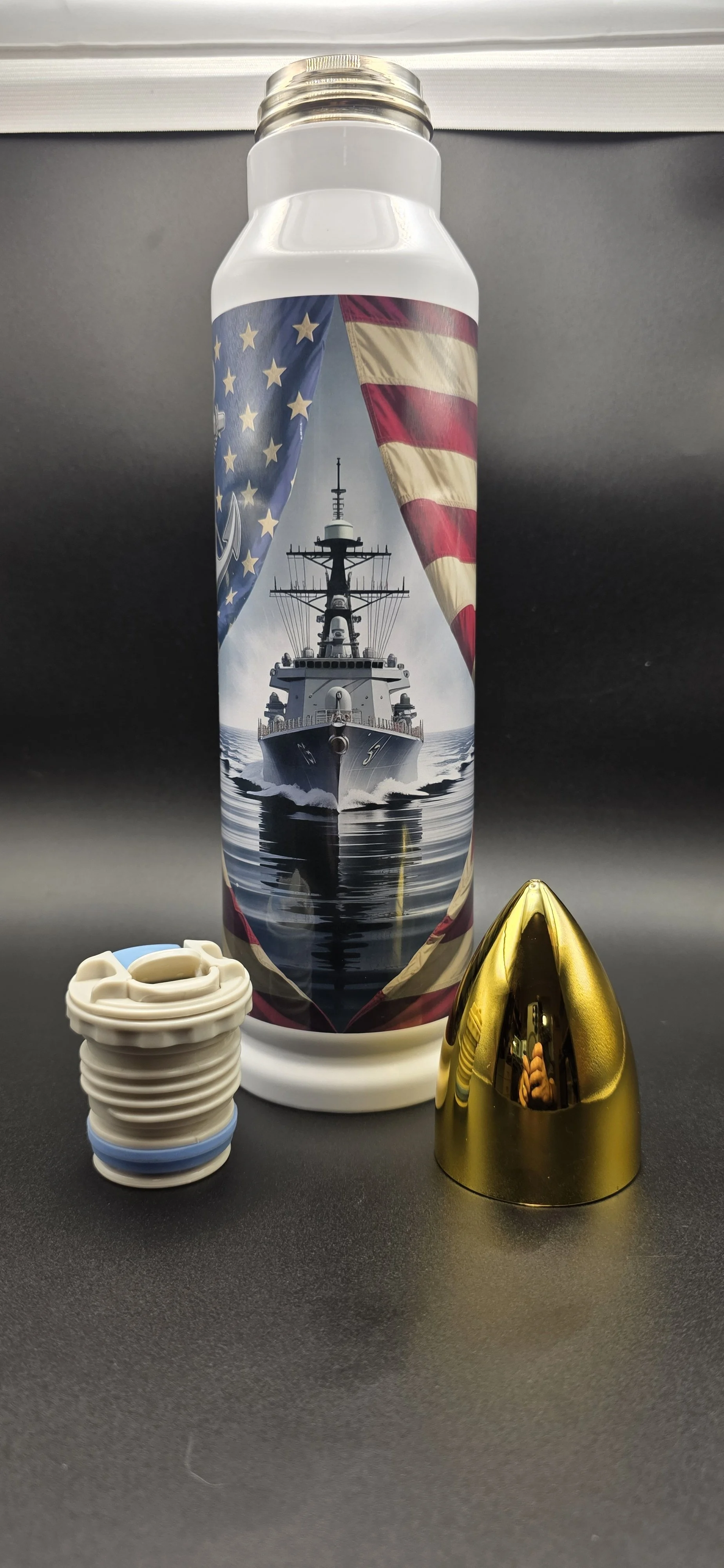 Custom U.S. Navy bullet-style tumbler with patriotic battleship artwork, shown with its removable gold bullet-shaped lid and cap.