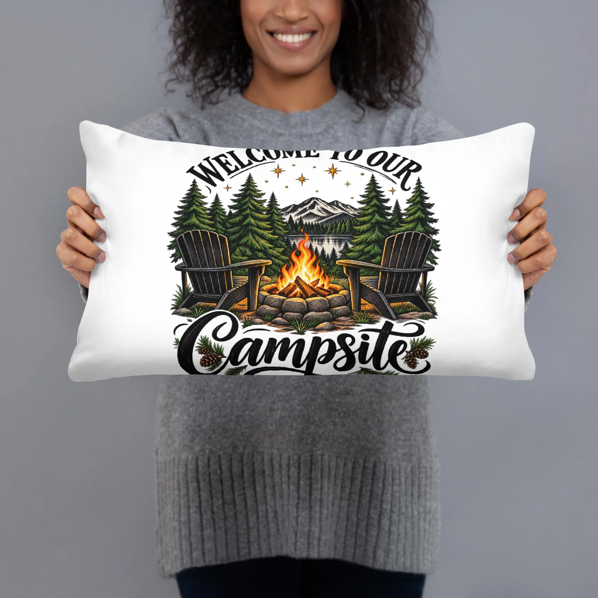 Welcome to Our Campsite camping throw pillow with camp chairs, campfire and pine trees, 20 by 12 inches, front view