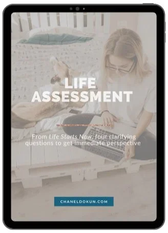 Cover of a guide titled 'Life Assessment' showing a woman sitting on a bed with a laptop. The subtitle reads 'From Life Starts Now, four clarifying questions to get immediate perspective.'