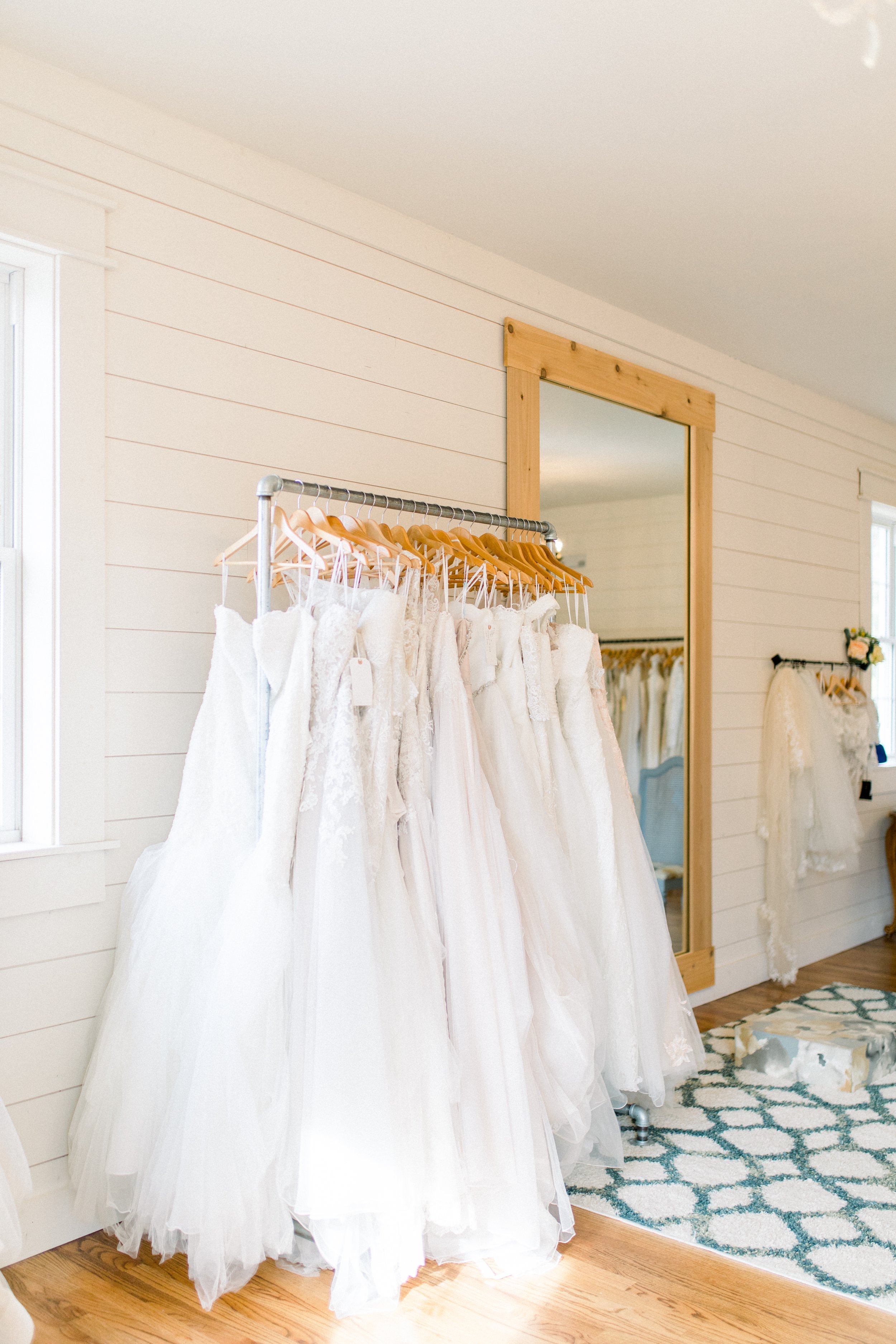 The Attic at Cleo Bridal dress try on room with racks of sample sale wedding gowns