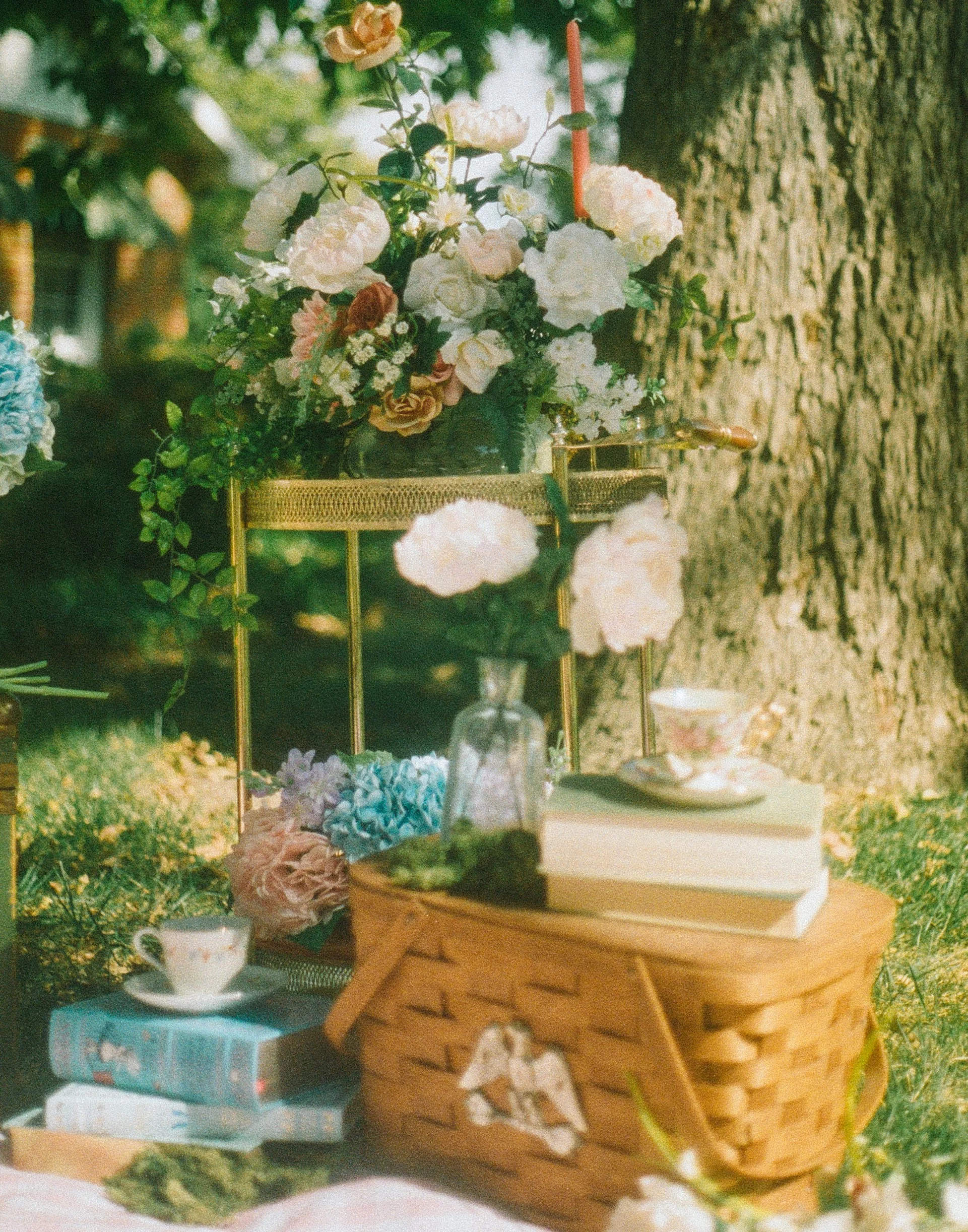 styled shot of cottage-core picnic with aesthetic books and flowers. Link to learn more about the stylists at cleo bridal