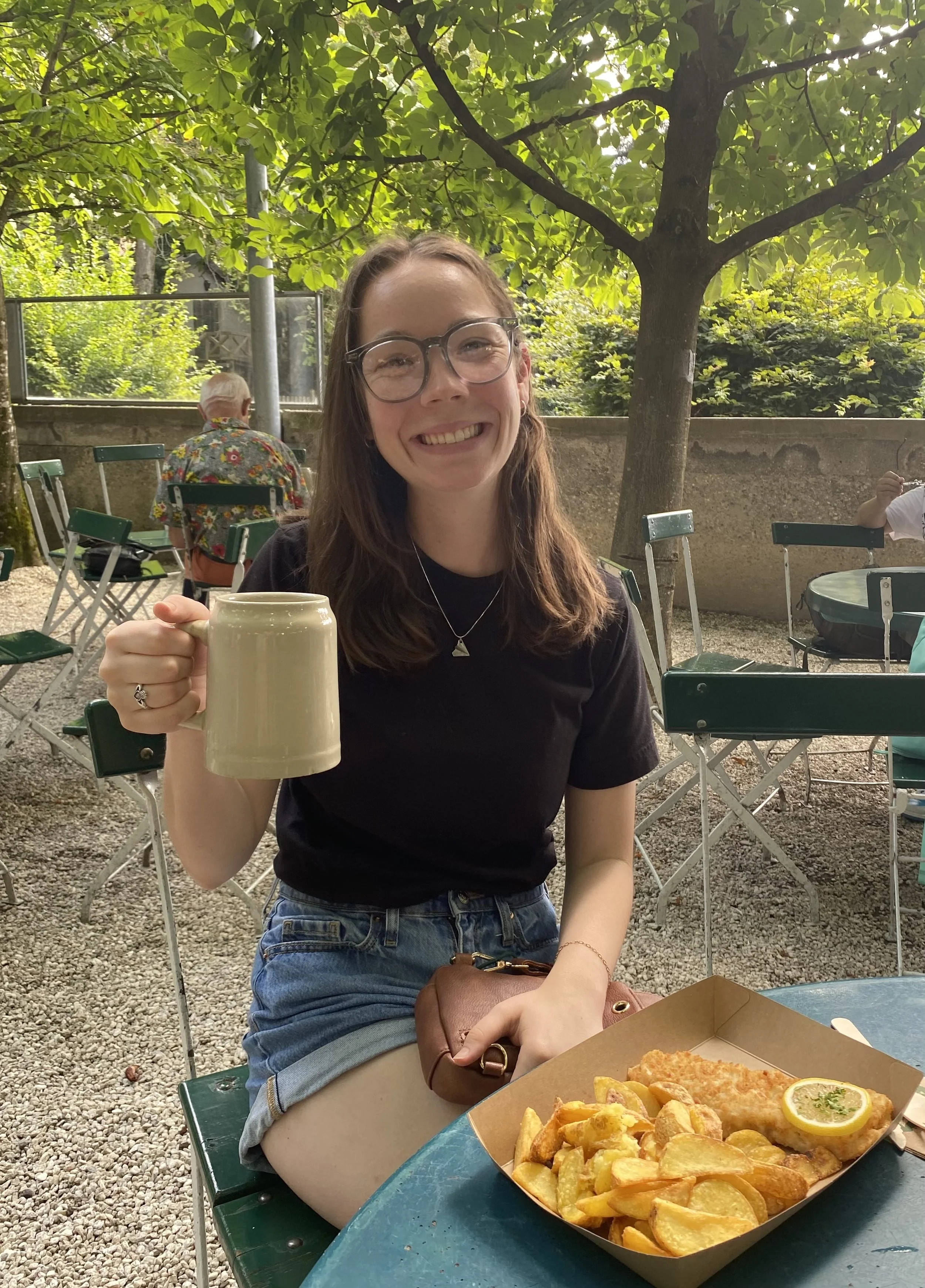 photo of Octavia, stylist, wearing a black t-shirt and jean shorts, sitting at a restaurant