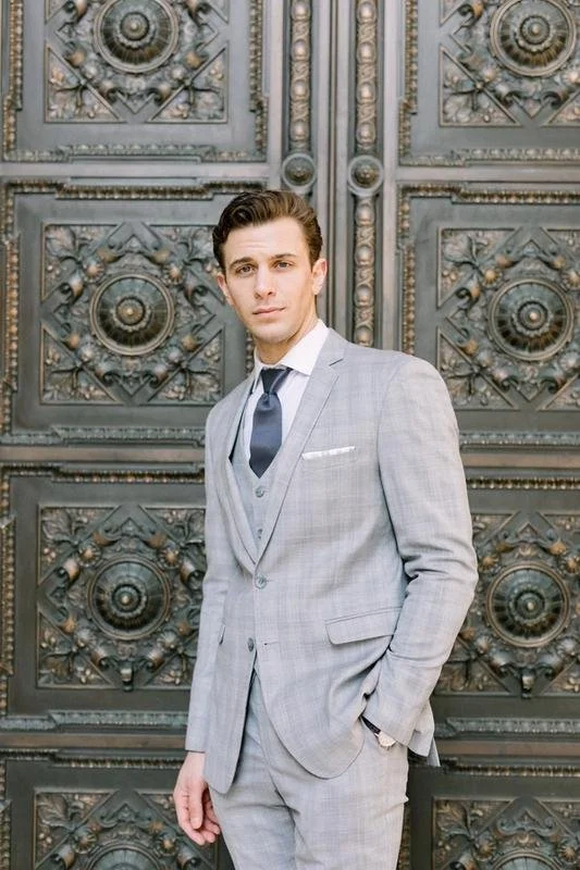 generation tux suit rental featuring male model in a grey plaid suit and nay tie