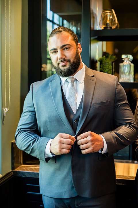 Friar Tux suit featuring male model in a charcoal grey suit and light grey tie