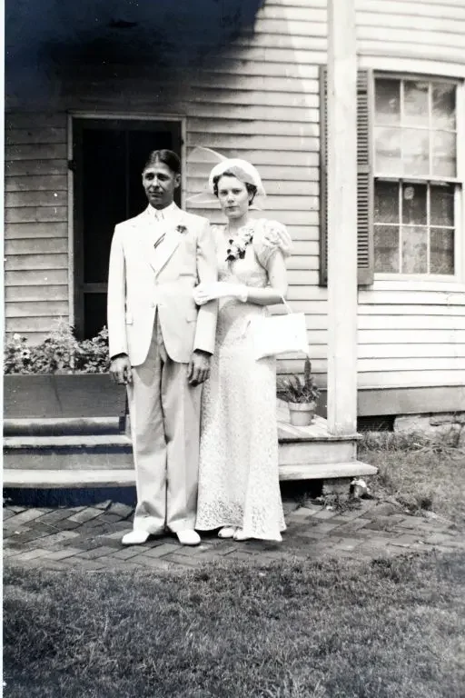 black and white image of newly married couple in front of historic Krekel house in O'Fallon Missouri